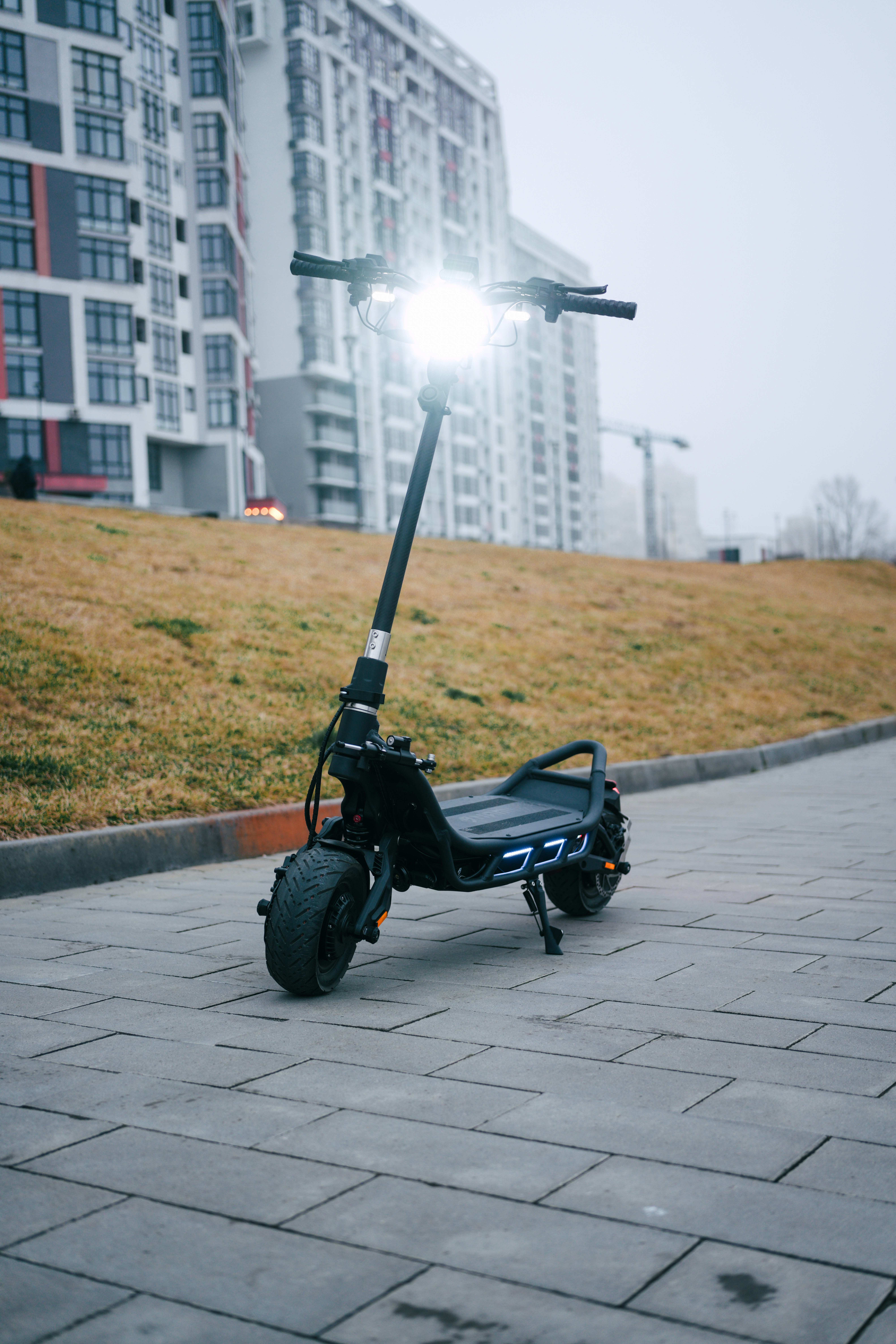 A scooter is parked on the sidewalk in front of a building