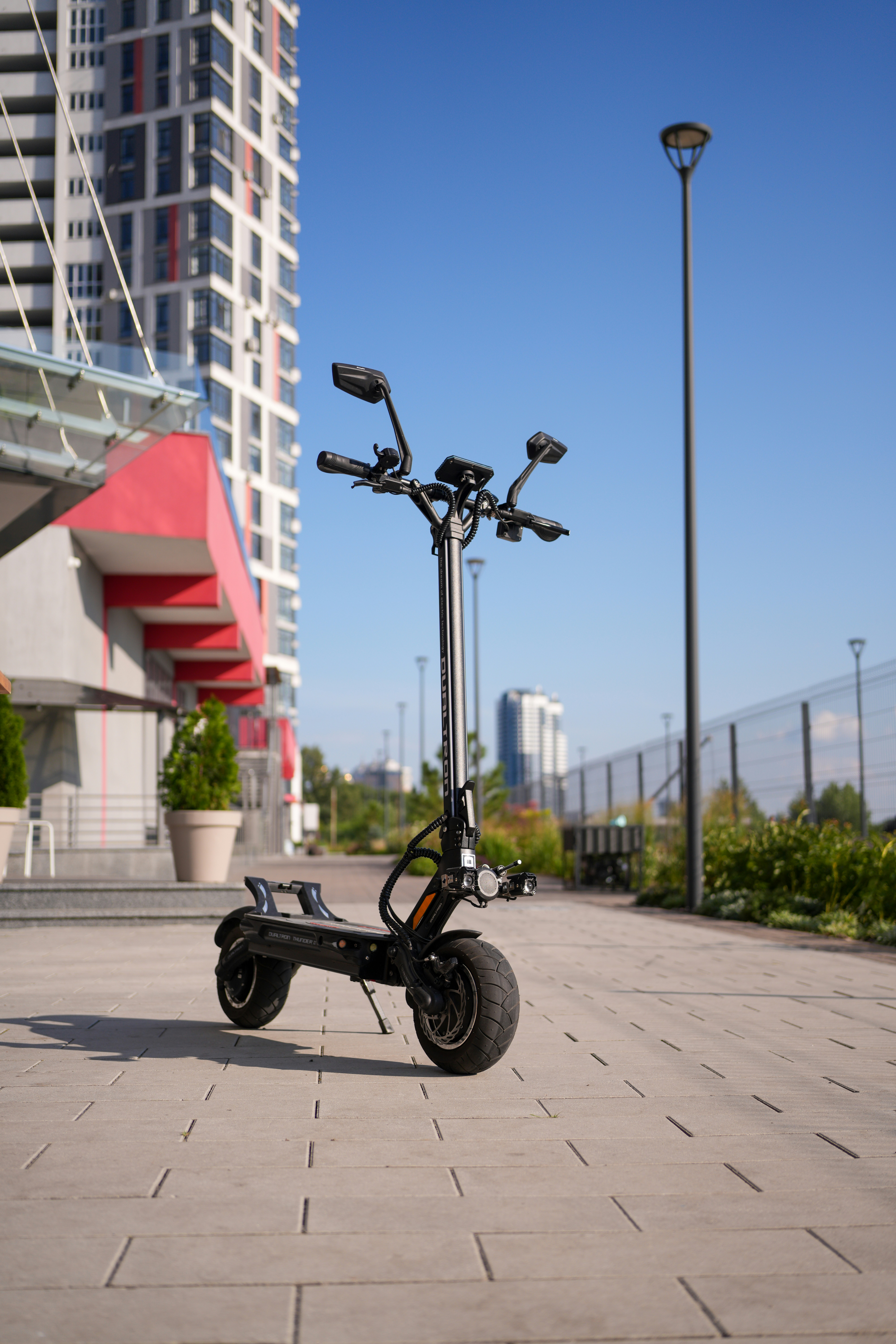 An electric scooter parked in front of a tall building