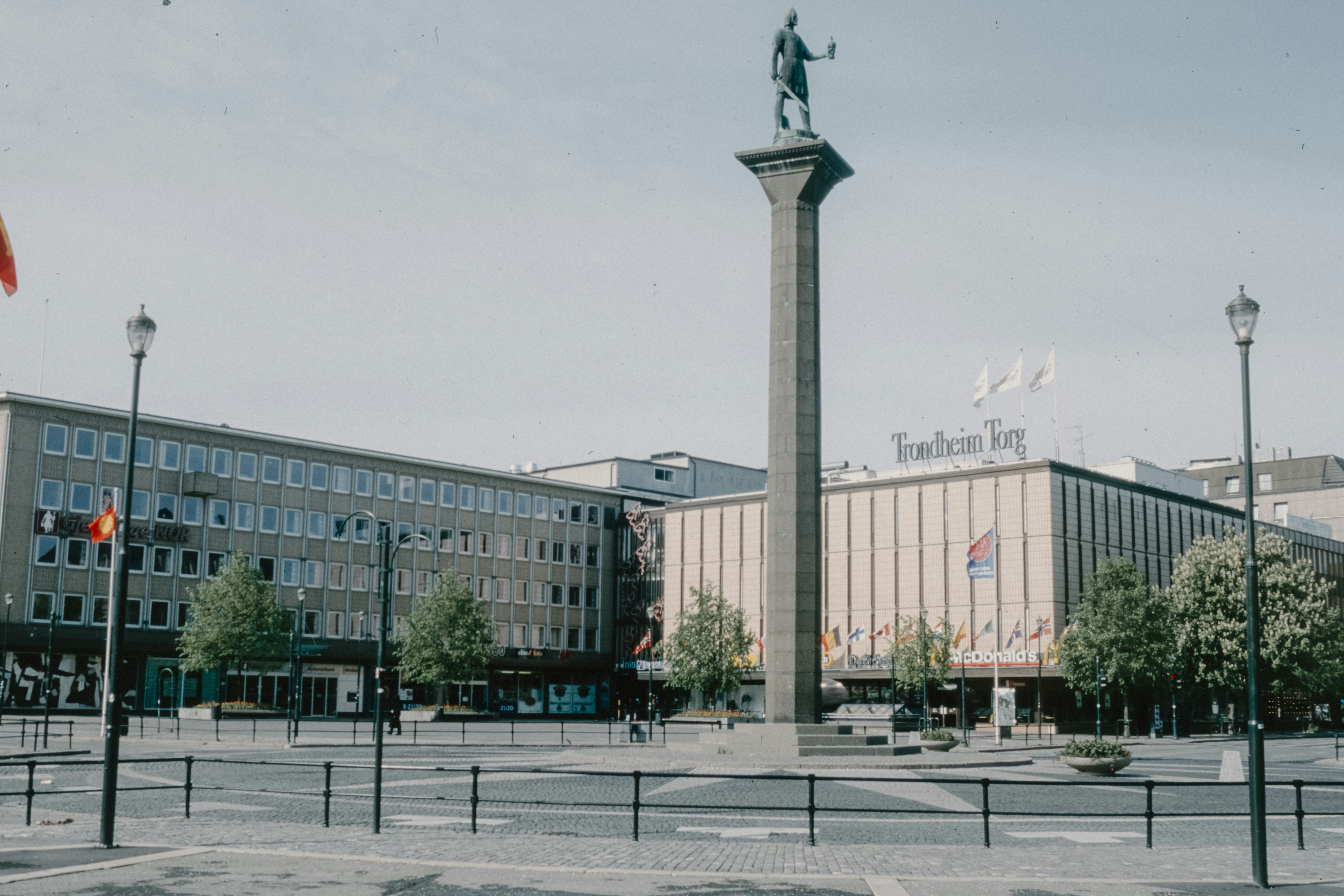 A statue of a man standing on top of a pole