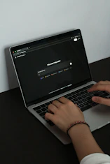 A person typing on a laptop on a table