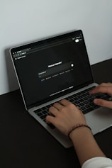 A person typing on a laptop on a table