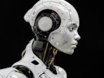 A white robot is standing in front of a black background
