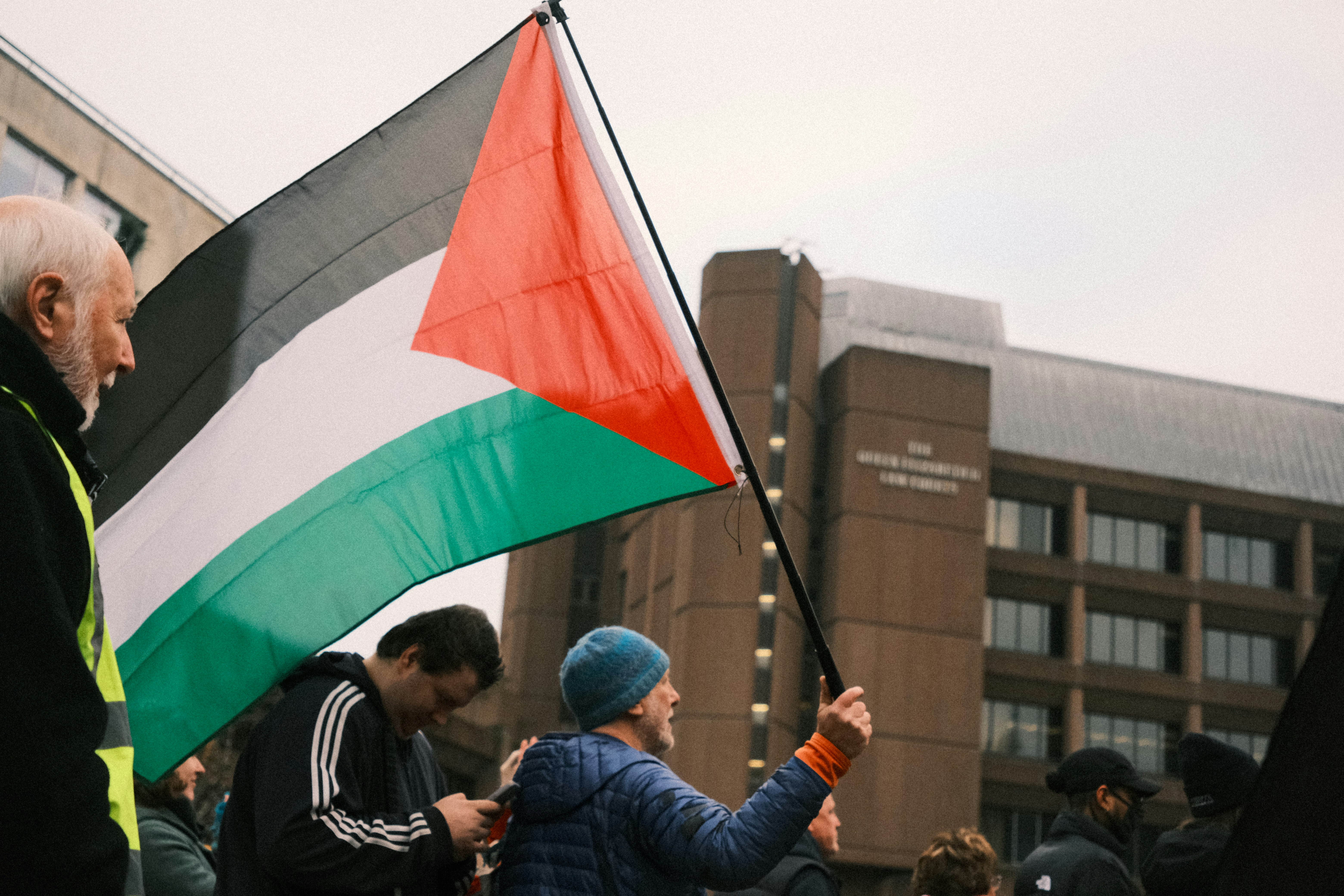 A man holding a flag in a crowd of people