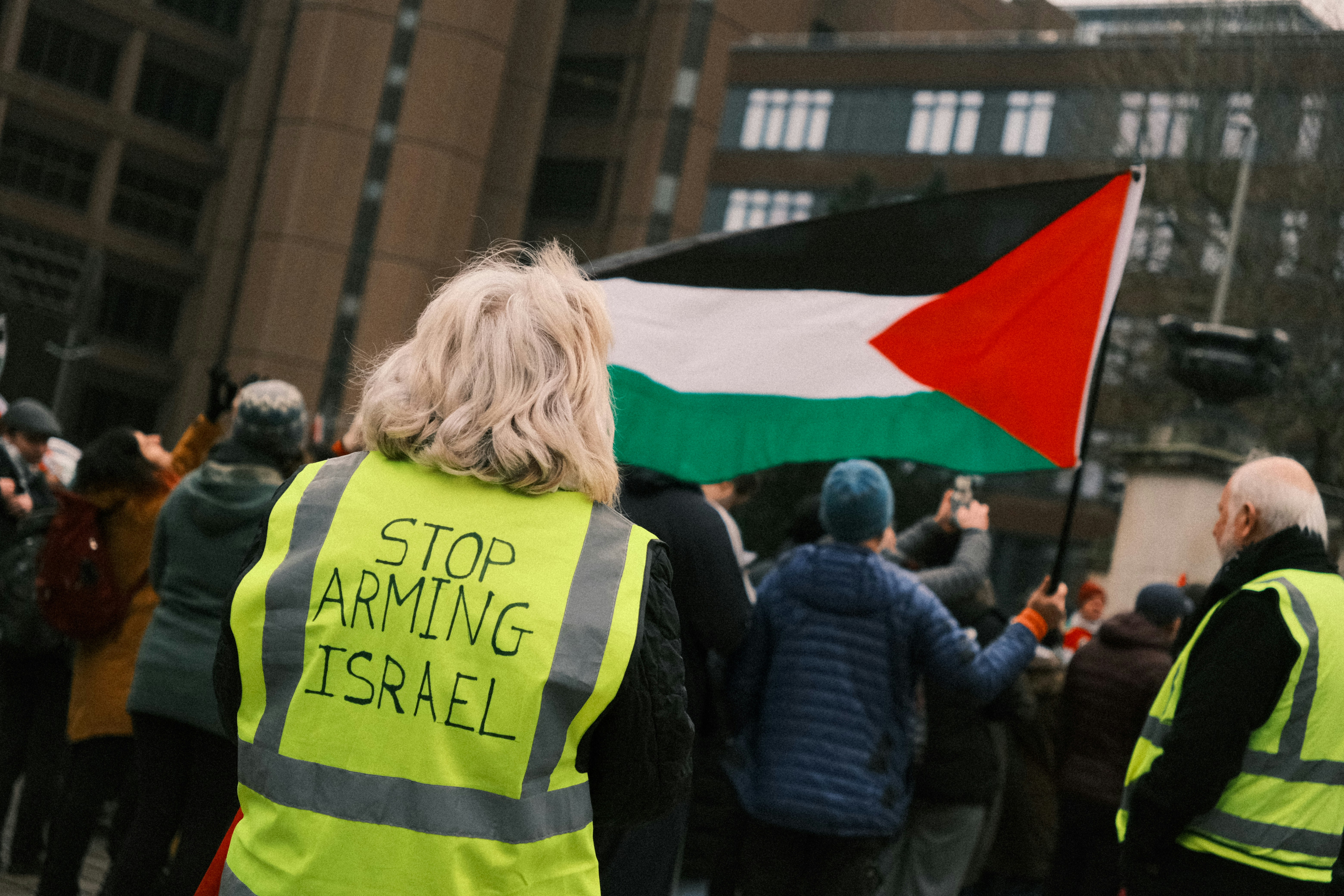 A group of people holding a flag and a sign