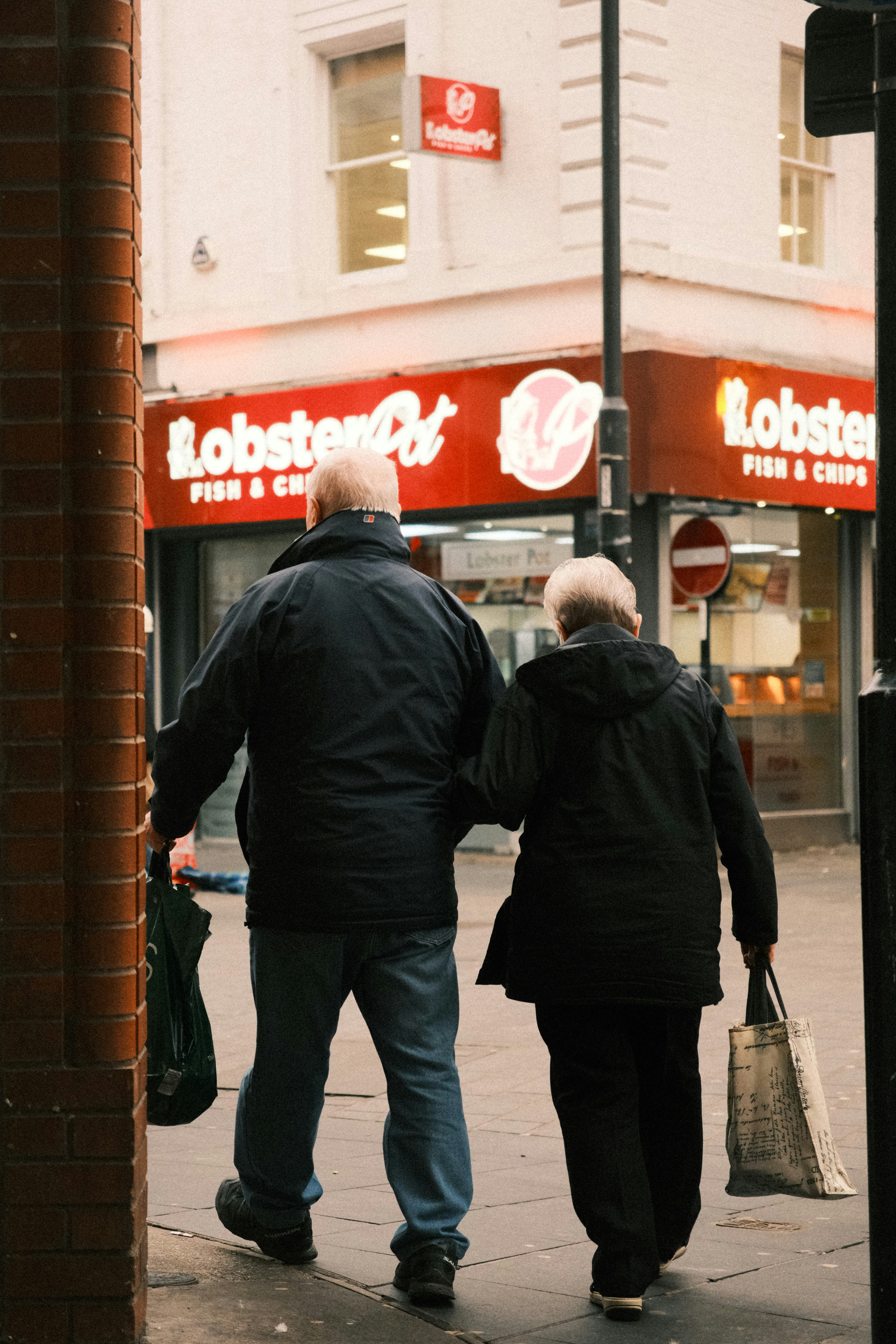 A couple of people walking down a street