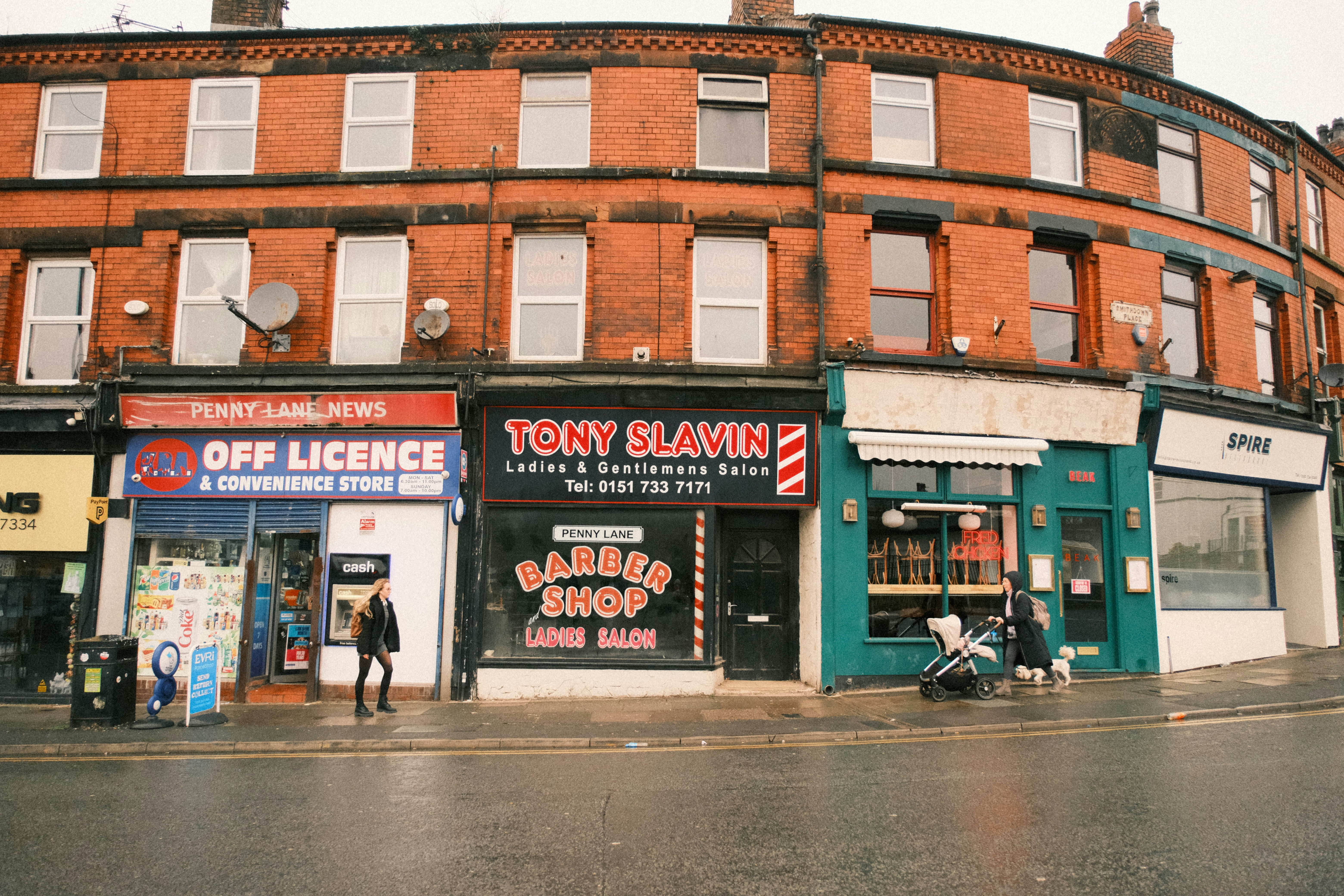 A street corner with a building and a motorcycle parked in front of it