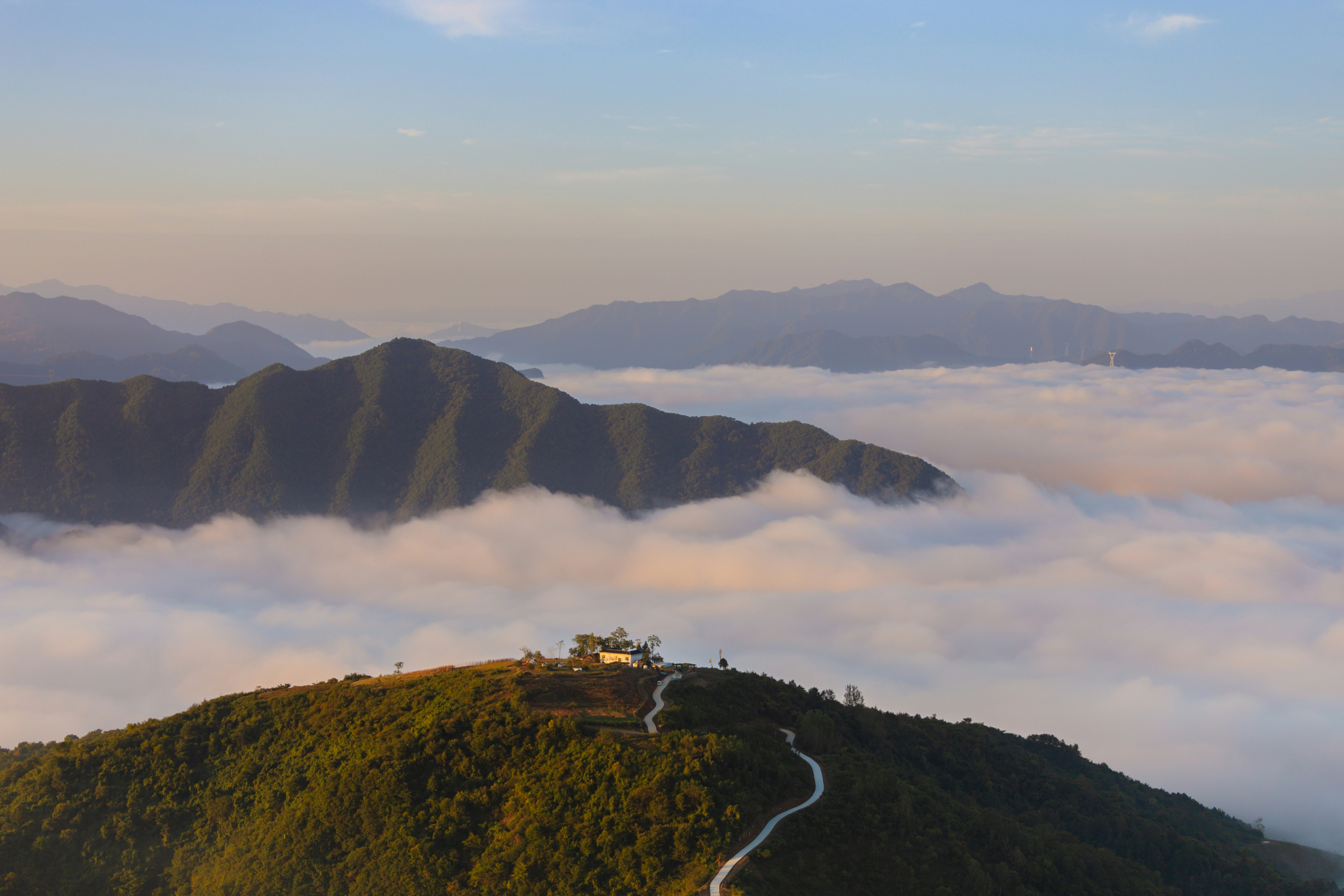 A mountain with a road going through the clouds