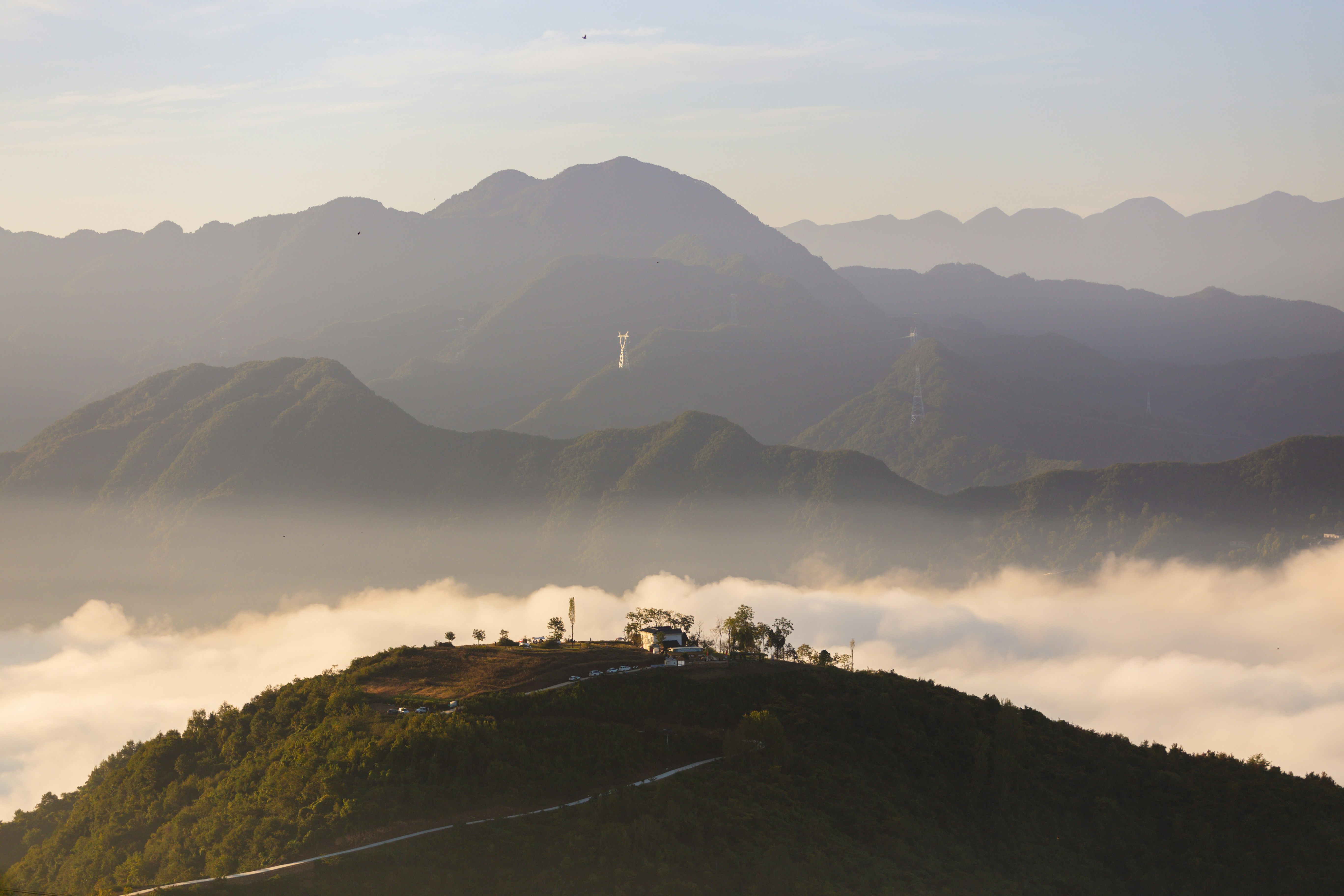 A hill covered in fog with a cross on top of it