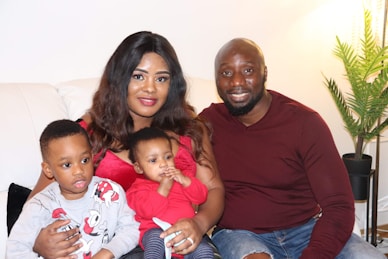 A man and woman sitting on a couch with two children