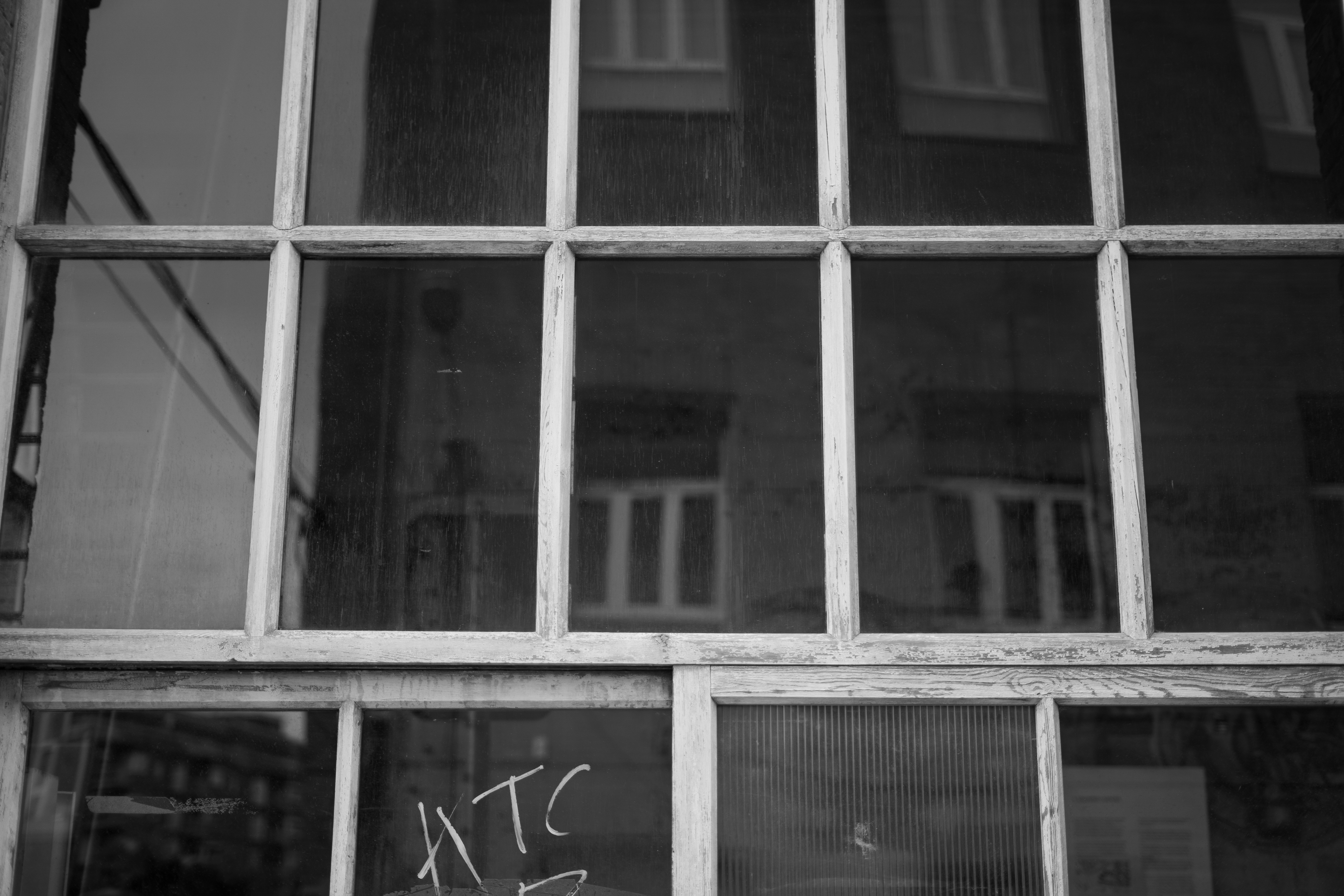 A black and white photo of a window with graffiti on it