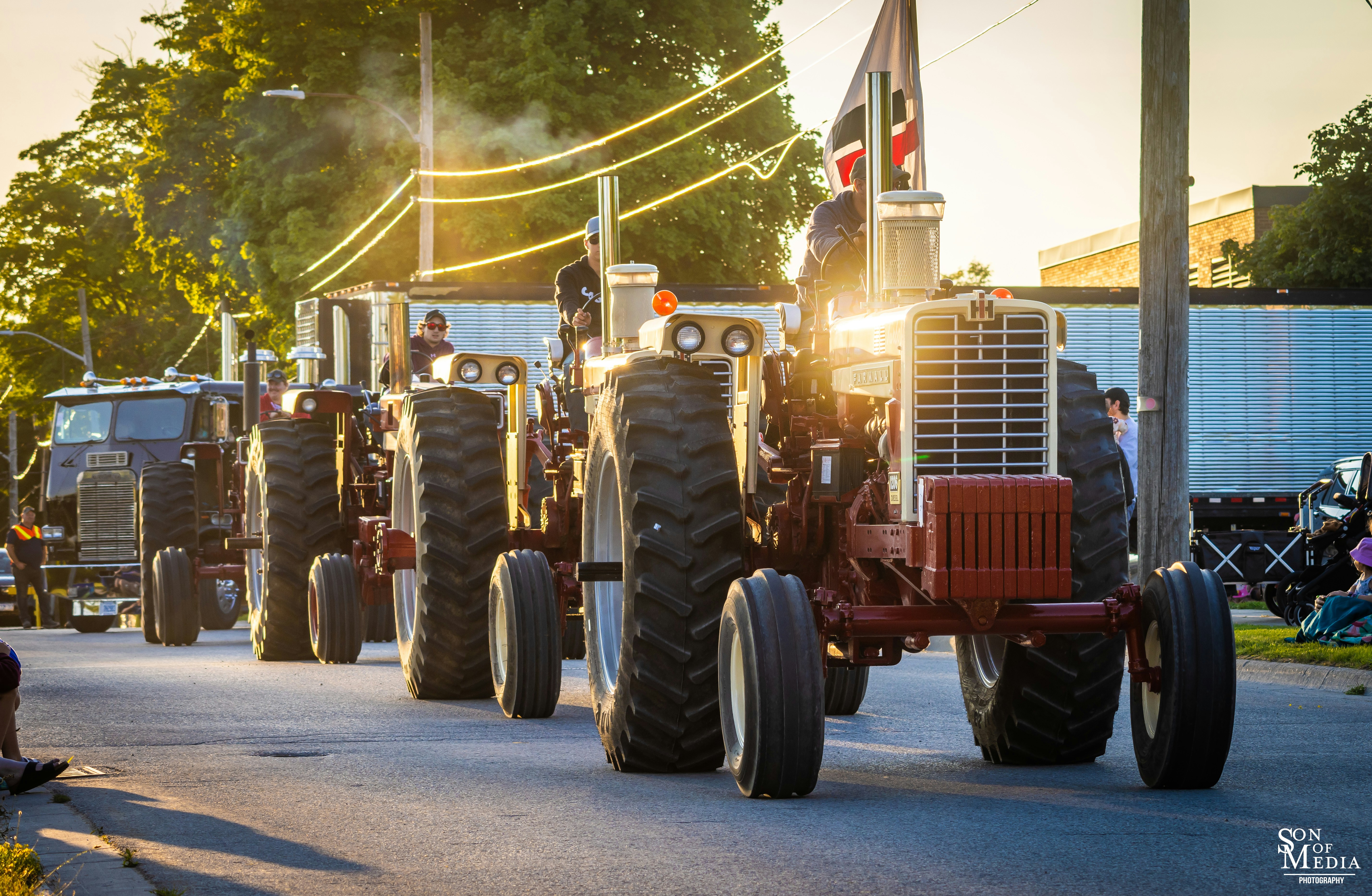 A group of tractors driving down a street