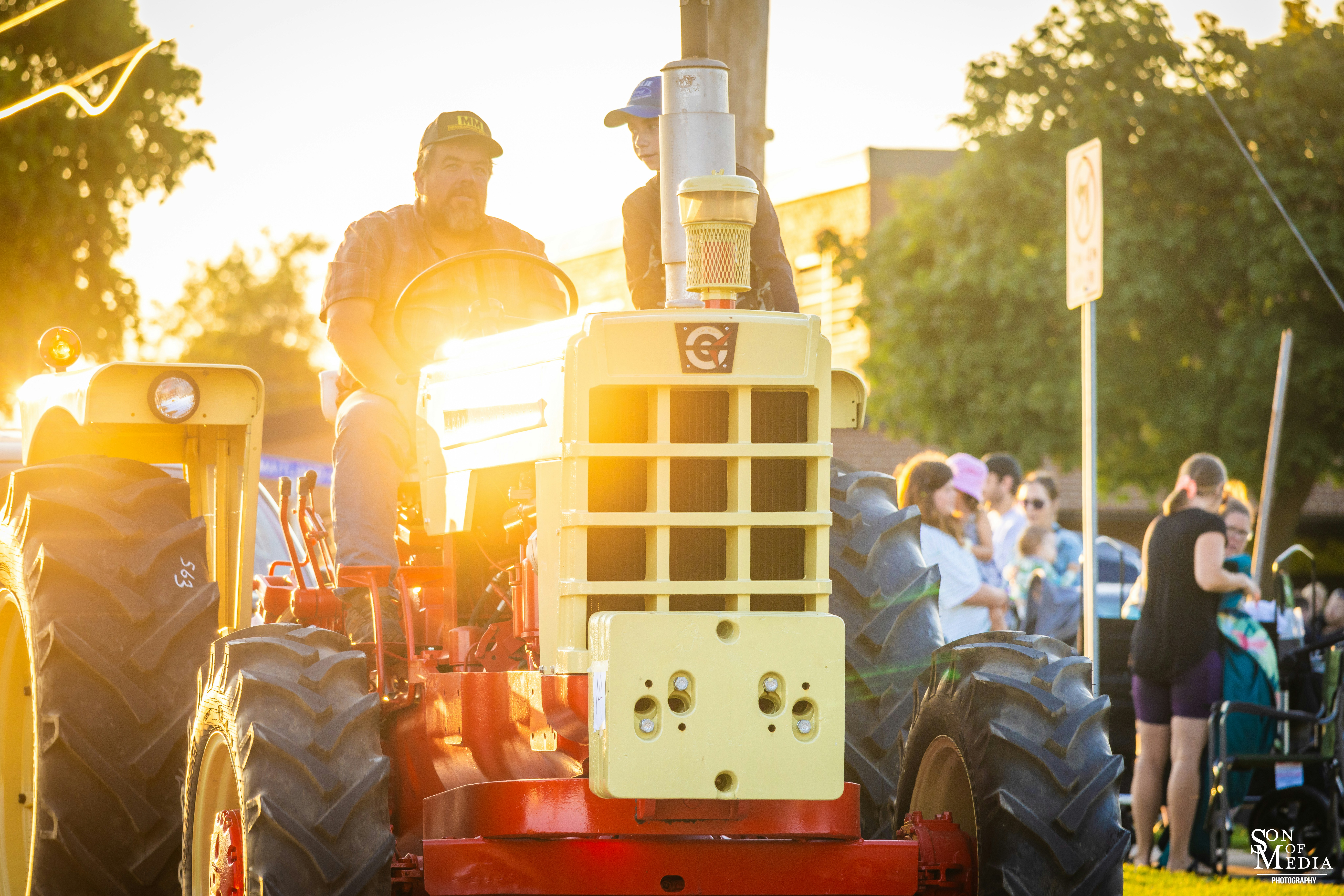 A man riding on the back of a red tractor