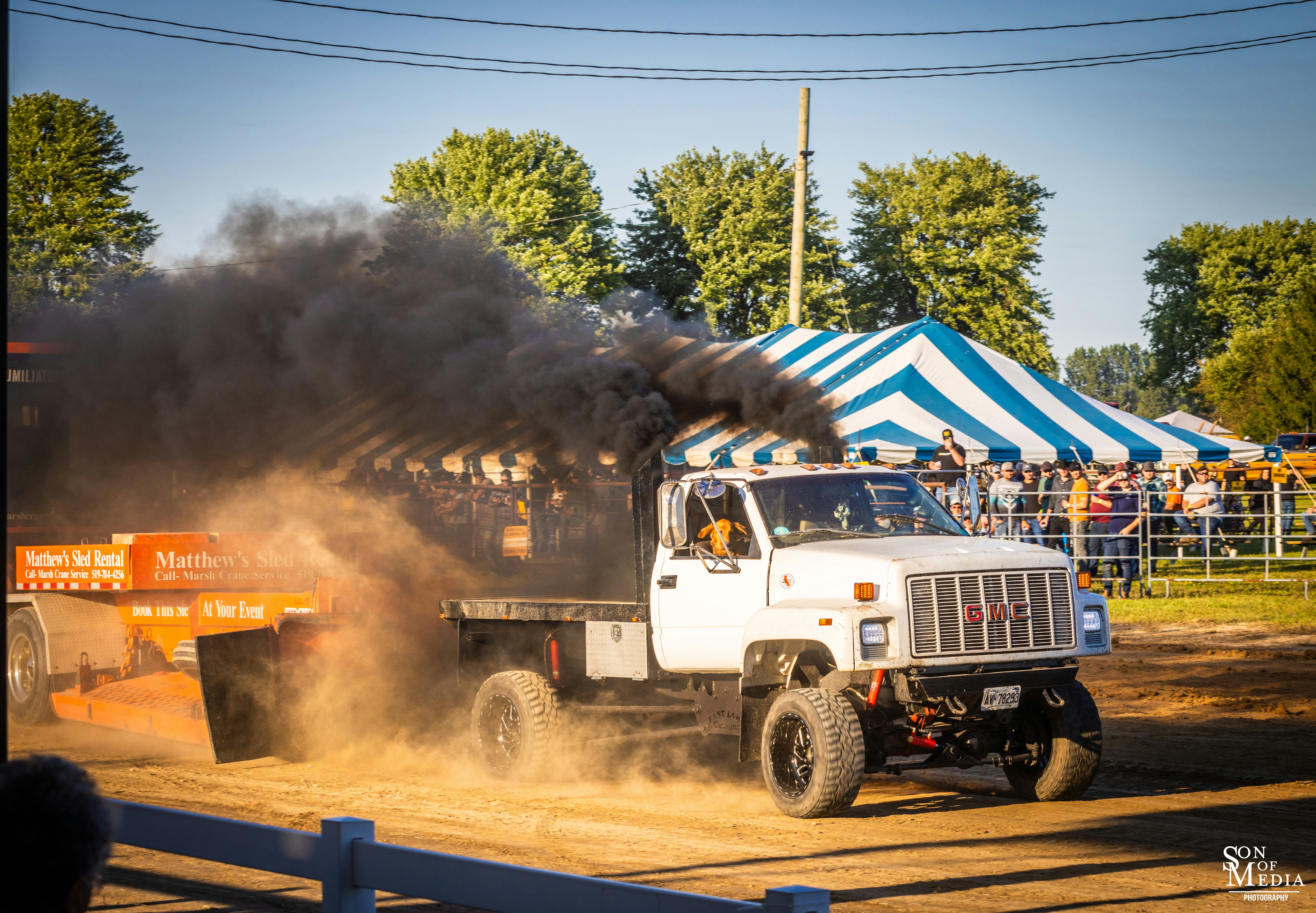 A white truck driving down a dirt road