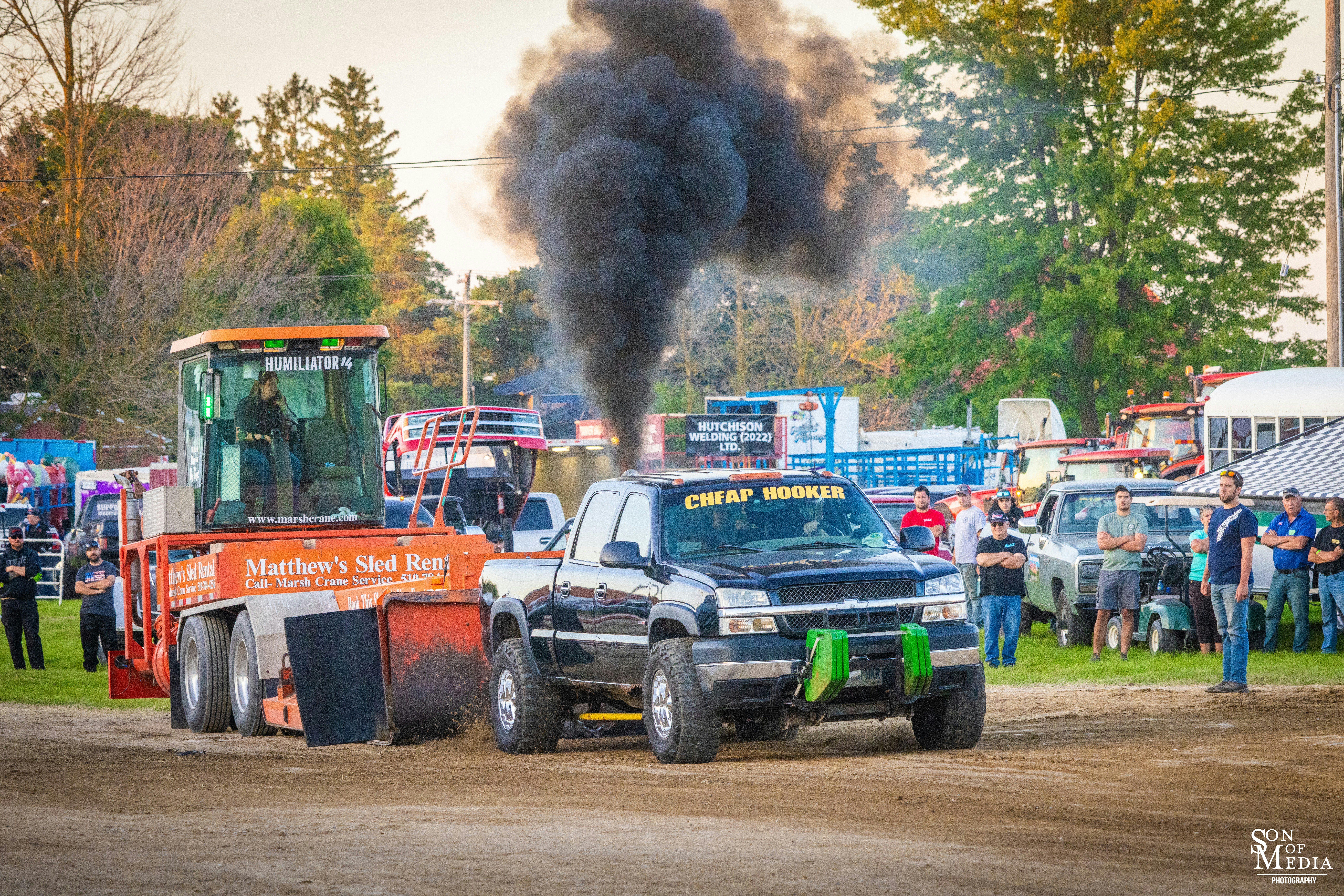 A truck and a tractor on a dirt road