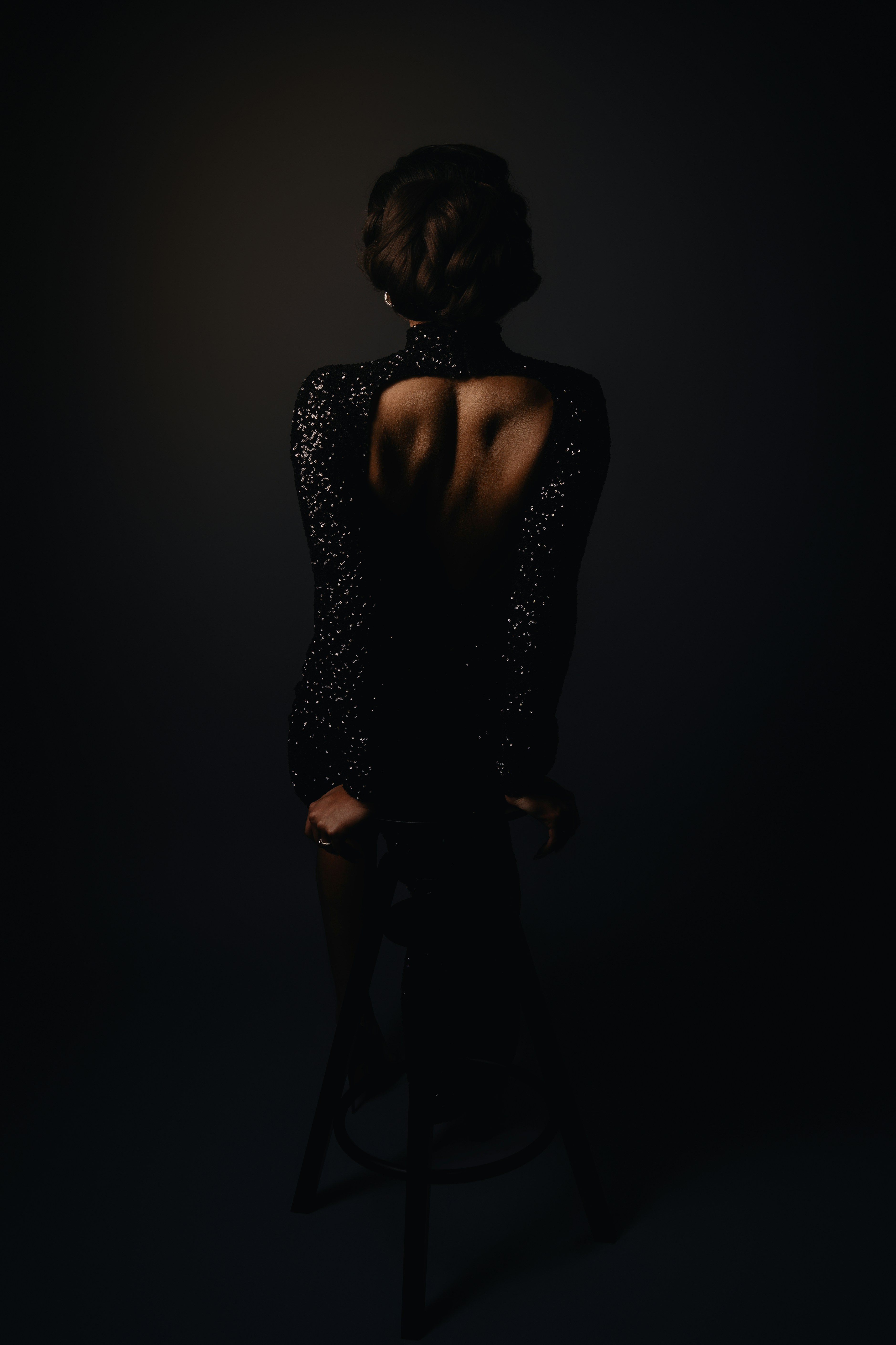 A woman standing in the dark with her back to the camera
