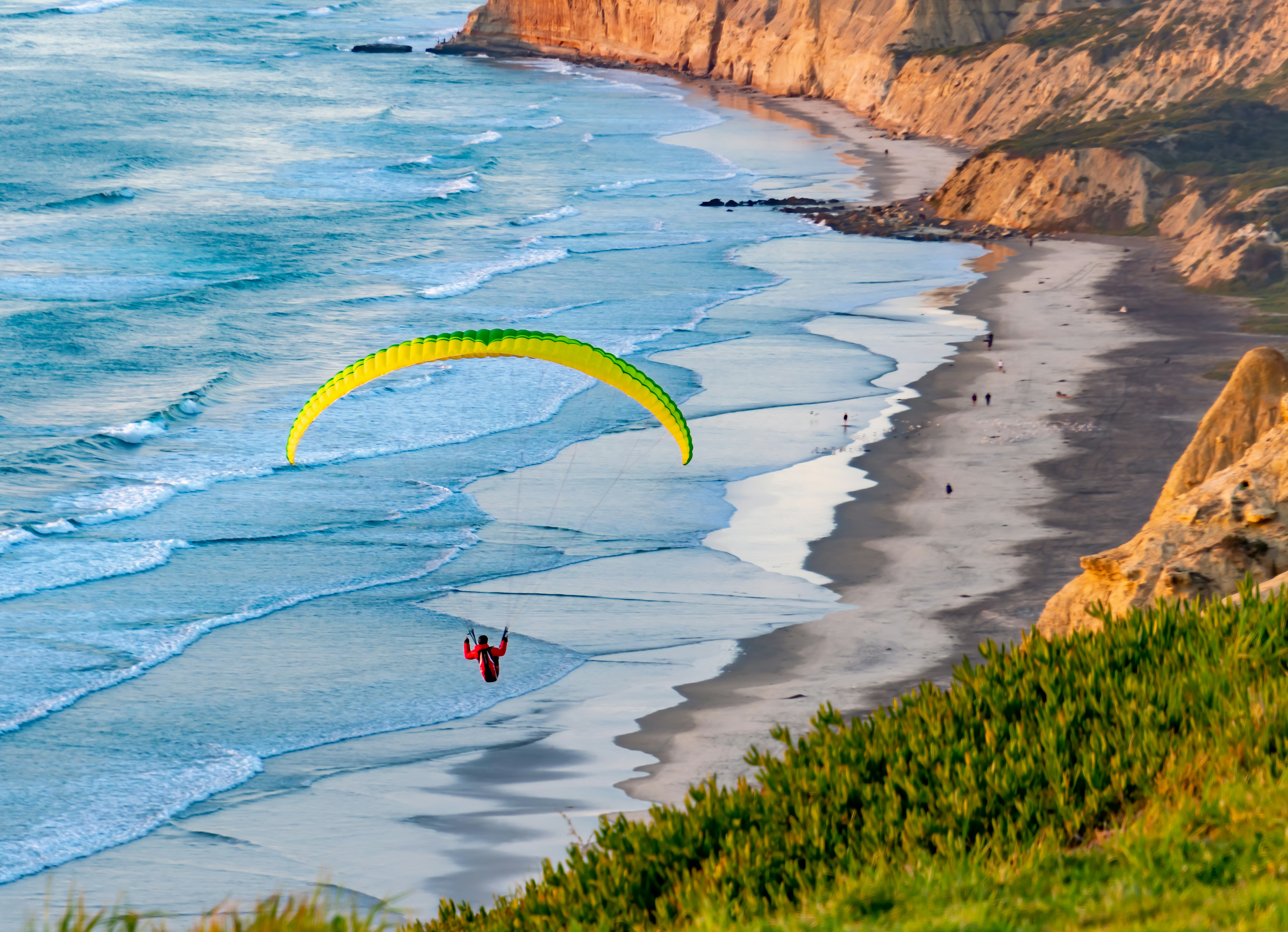 Un parapendio sorvola l'oceano in una giornata di sole
