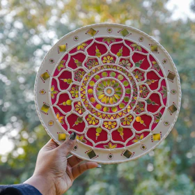 A person holding a plate with a design on it