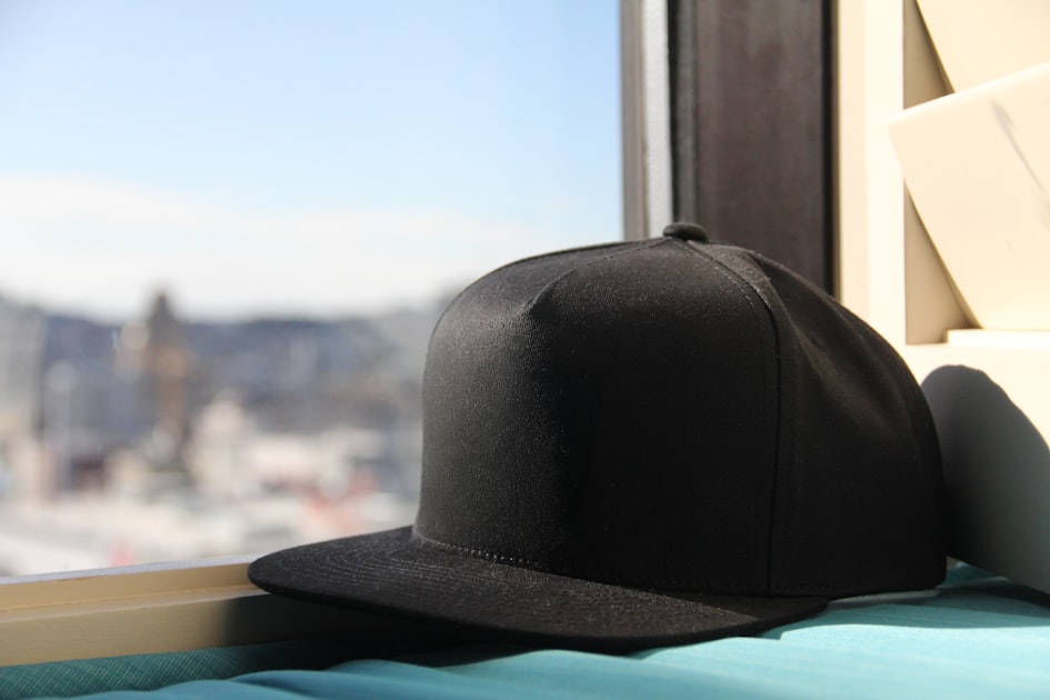 A black hat sitting on top of a window sill