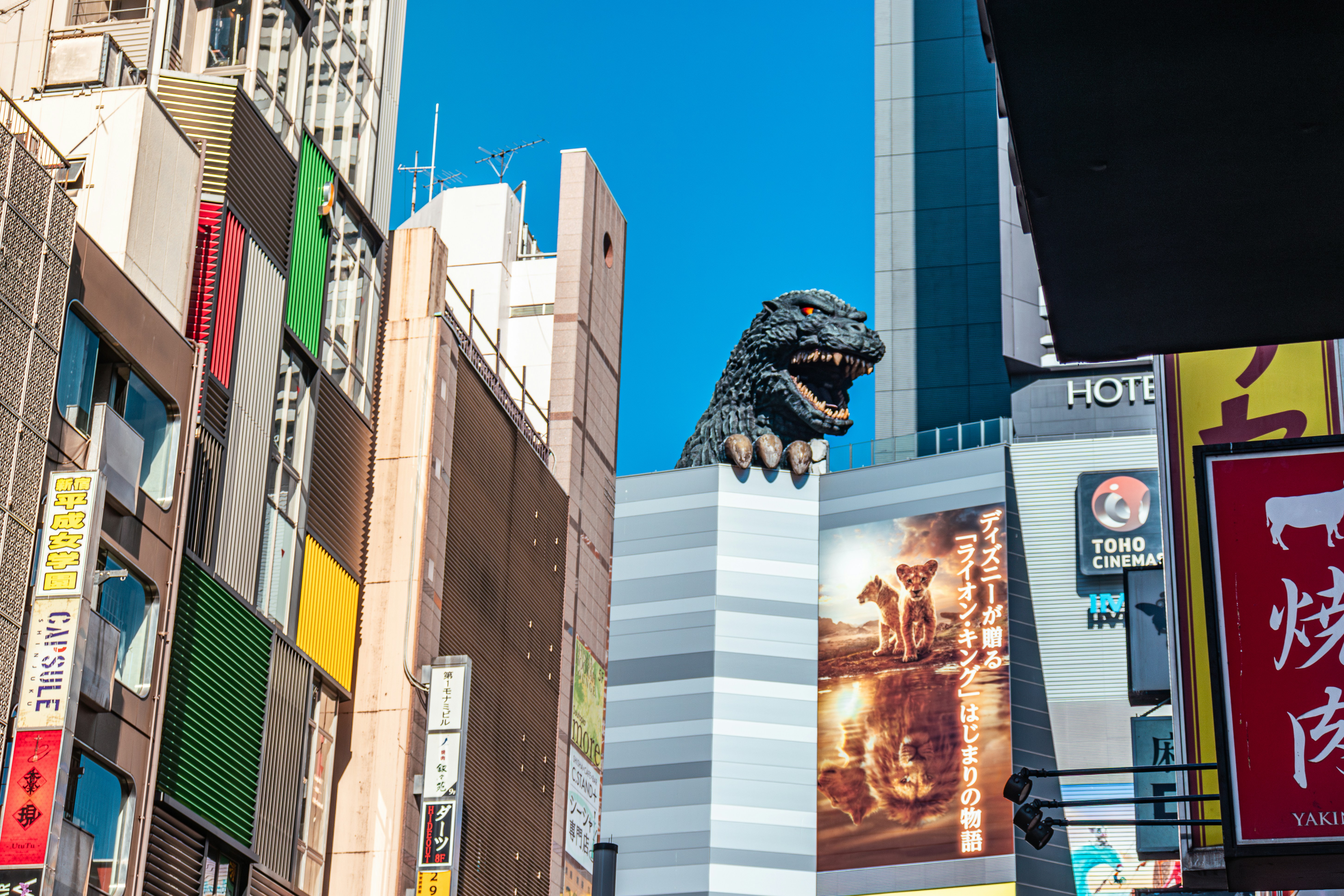 A large dinosaur statue on top of a tall building