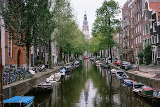 A narrow canal with boats in Amsterdam Netherlands