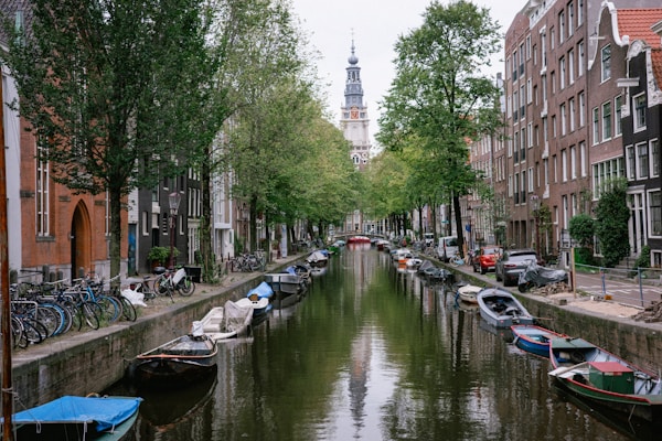 A narrow canal with boats in Amsterdam Netherlands