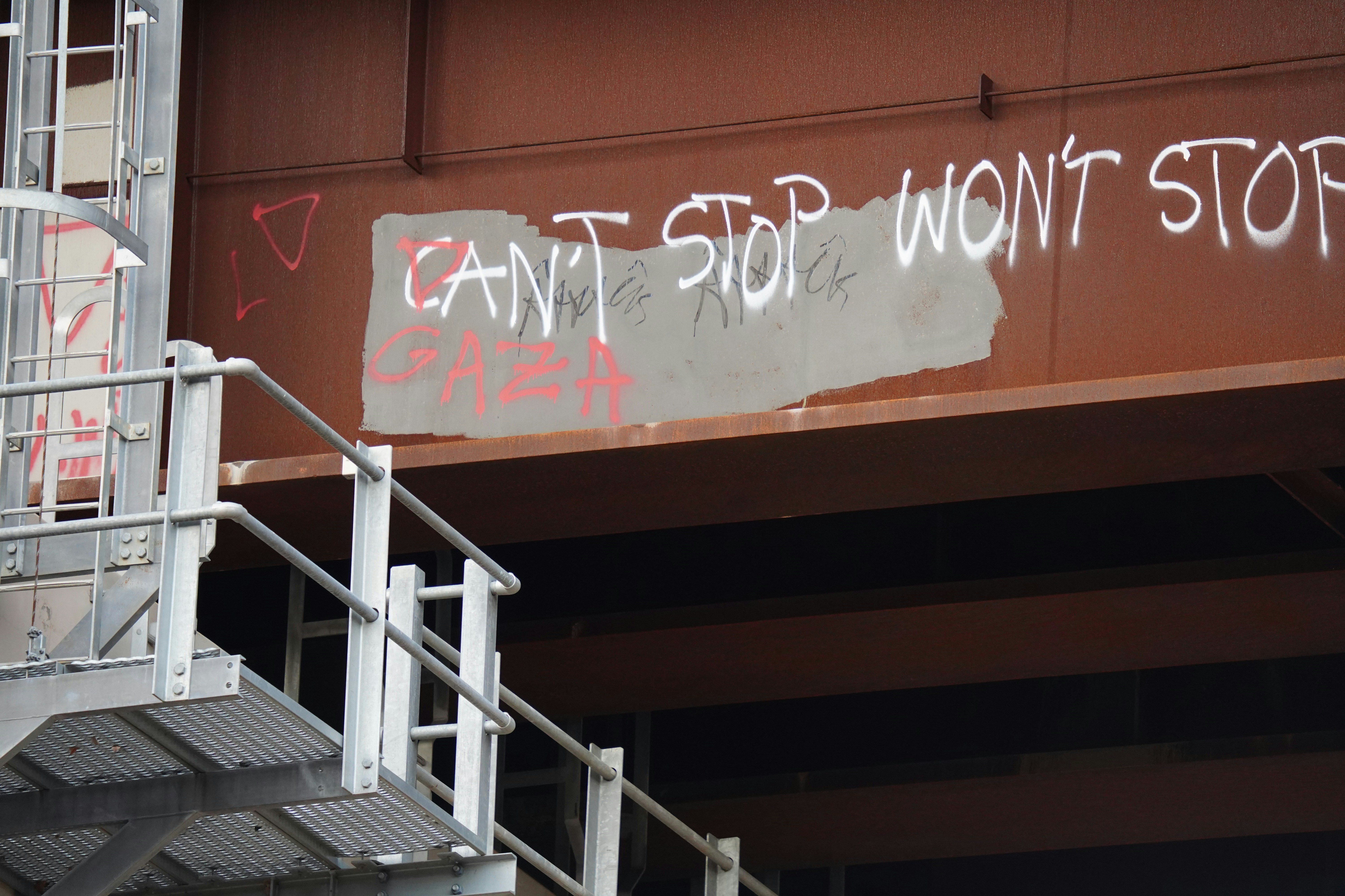 Graffiti on the side of a bridge reads can't stop won't stop