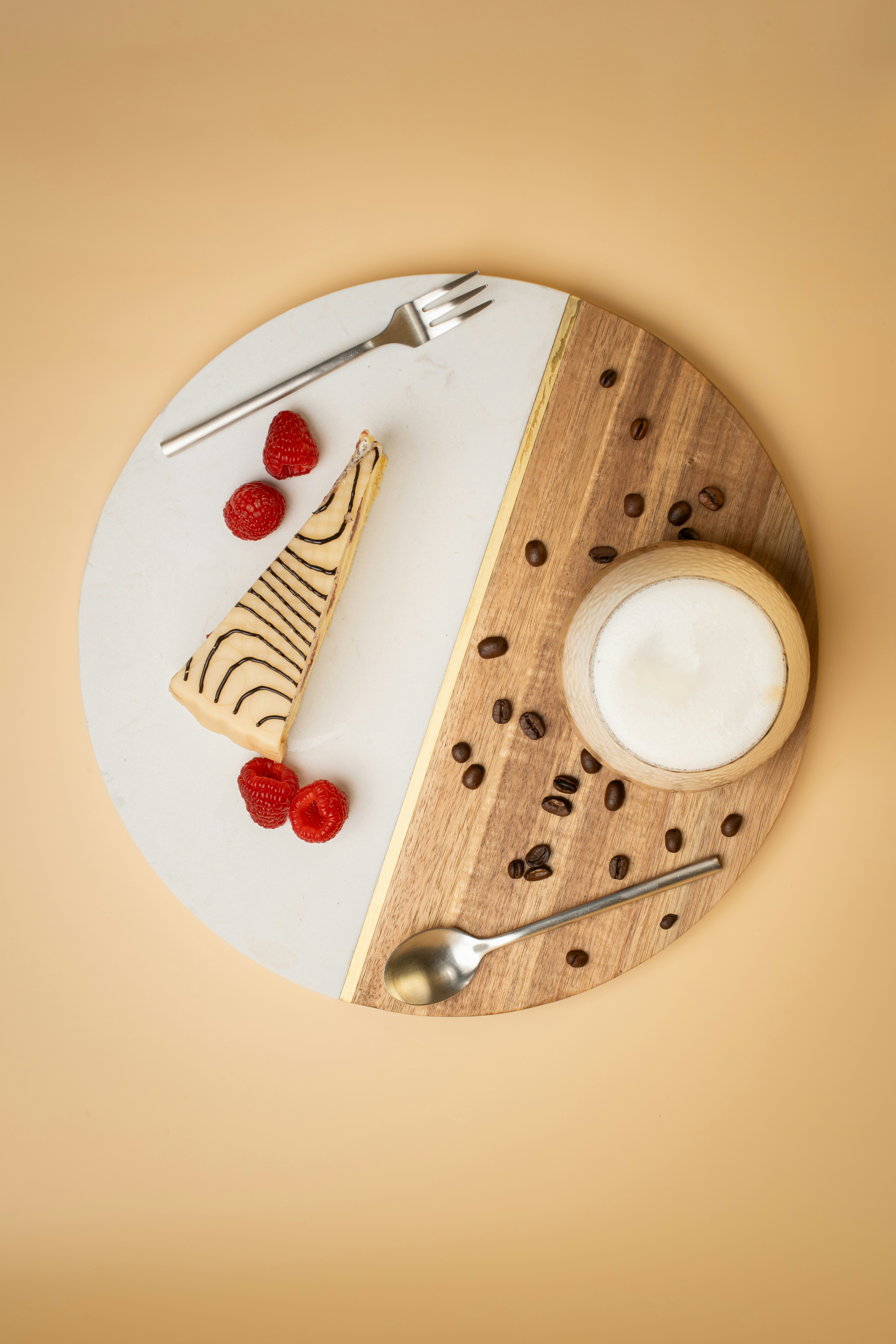 White plate with a slice of cake next to a cup of coffee