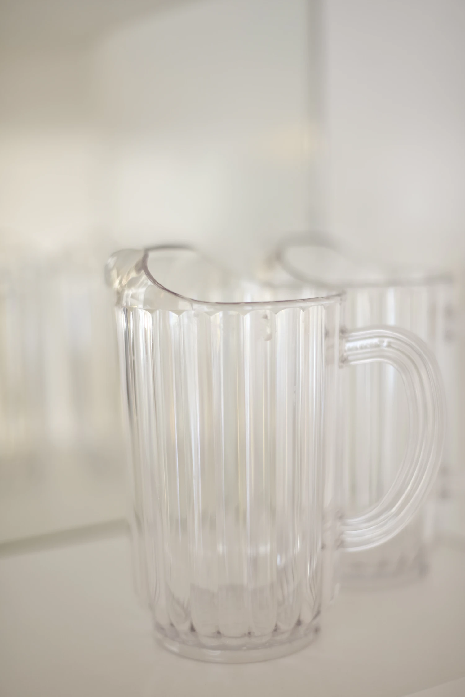 A pleated clear glass jug in soft white daylight