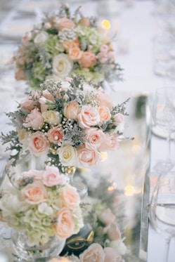 A table topped with tall vases filled with flowers