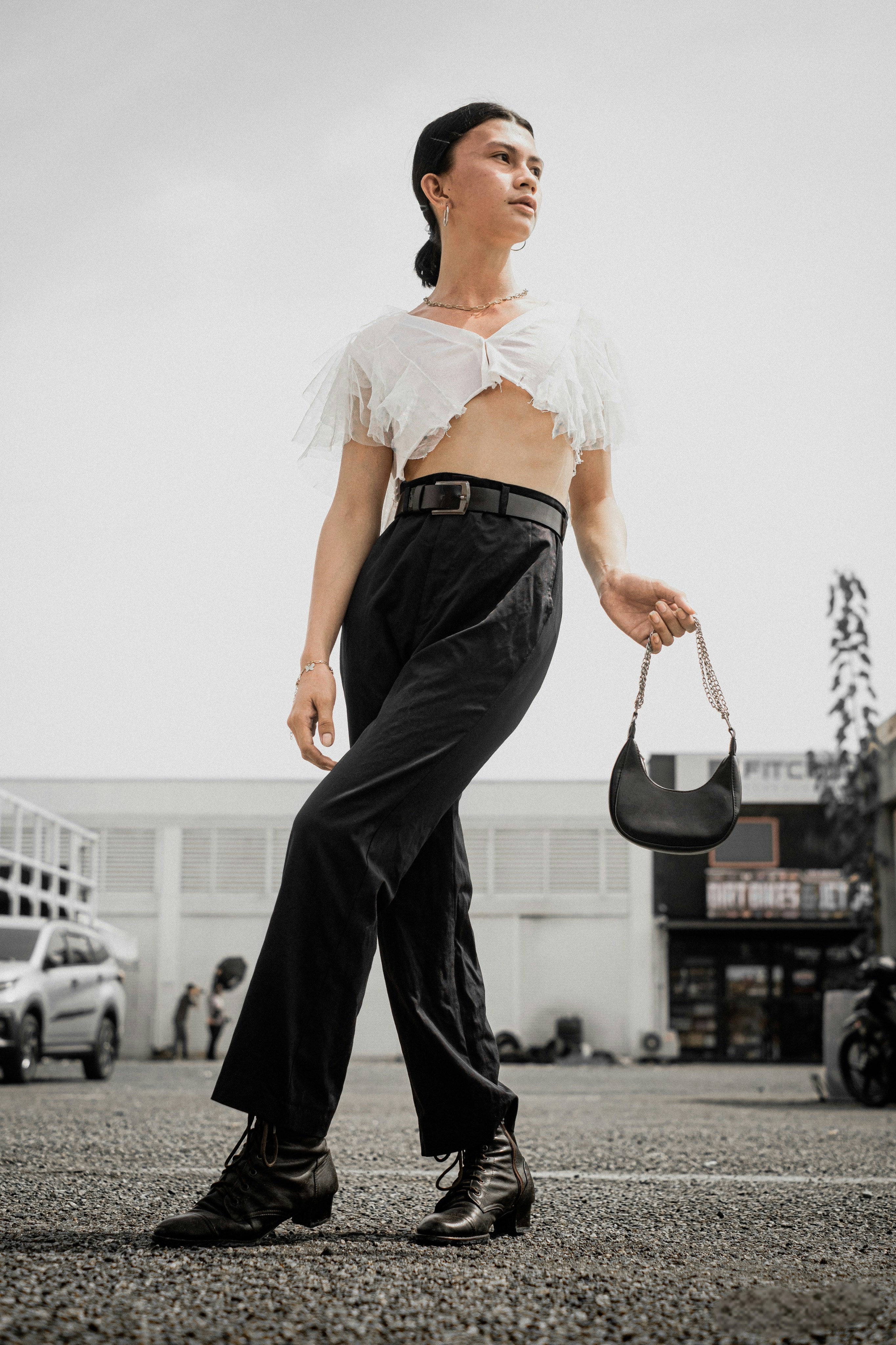 Una mujer con pantalones negros y un crop top blanco
