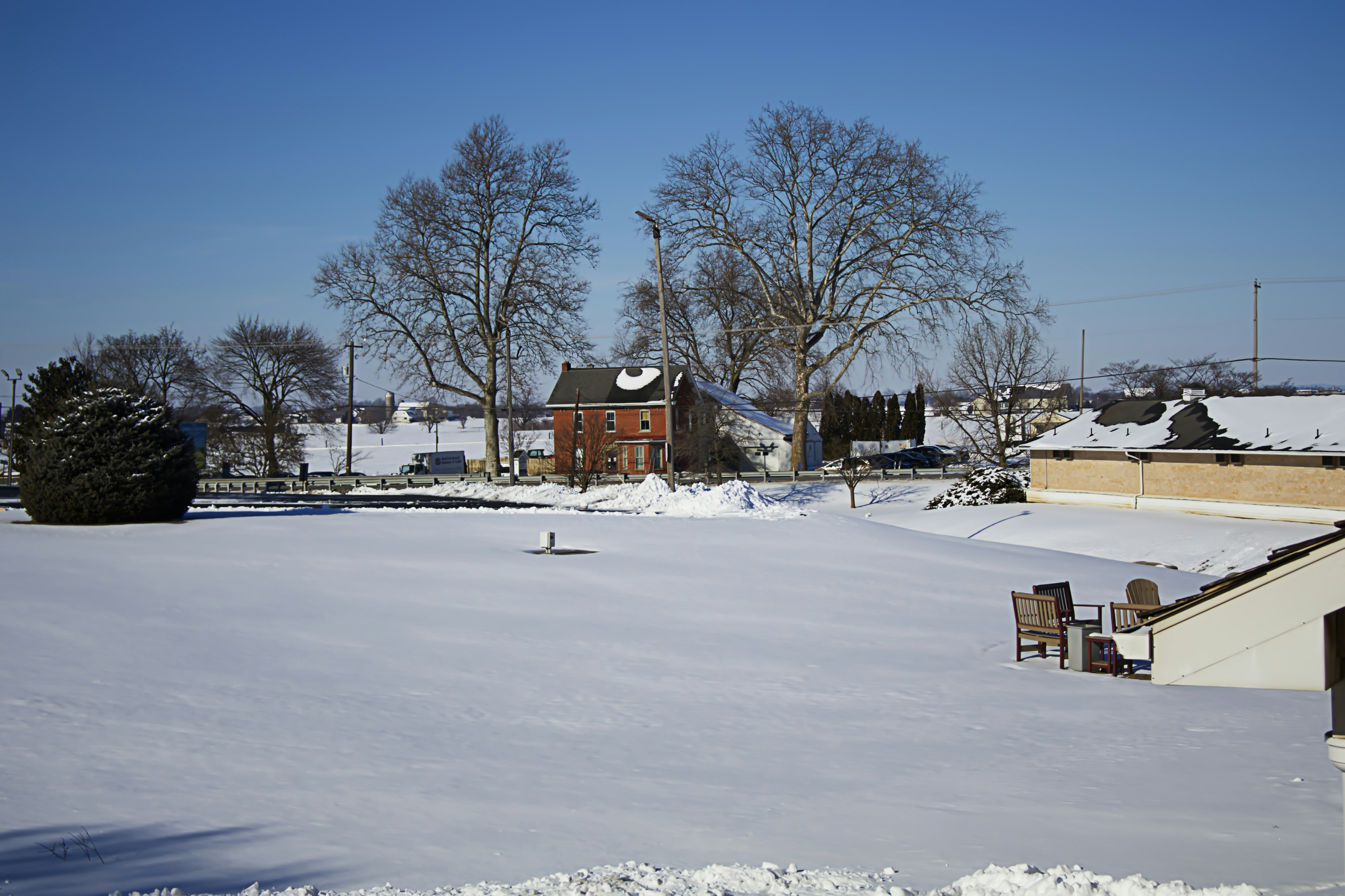 A snow covered field with a building in the background