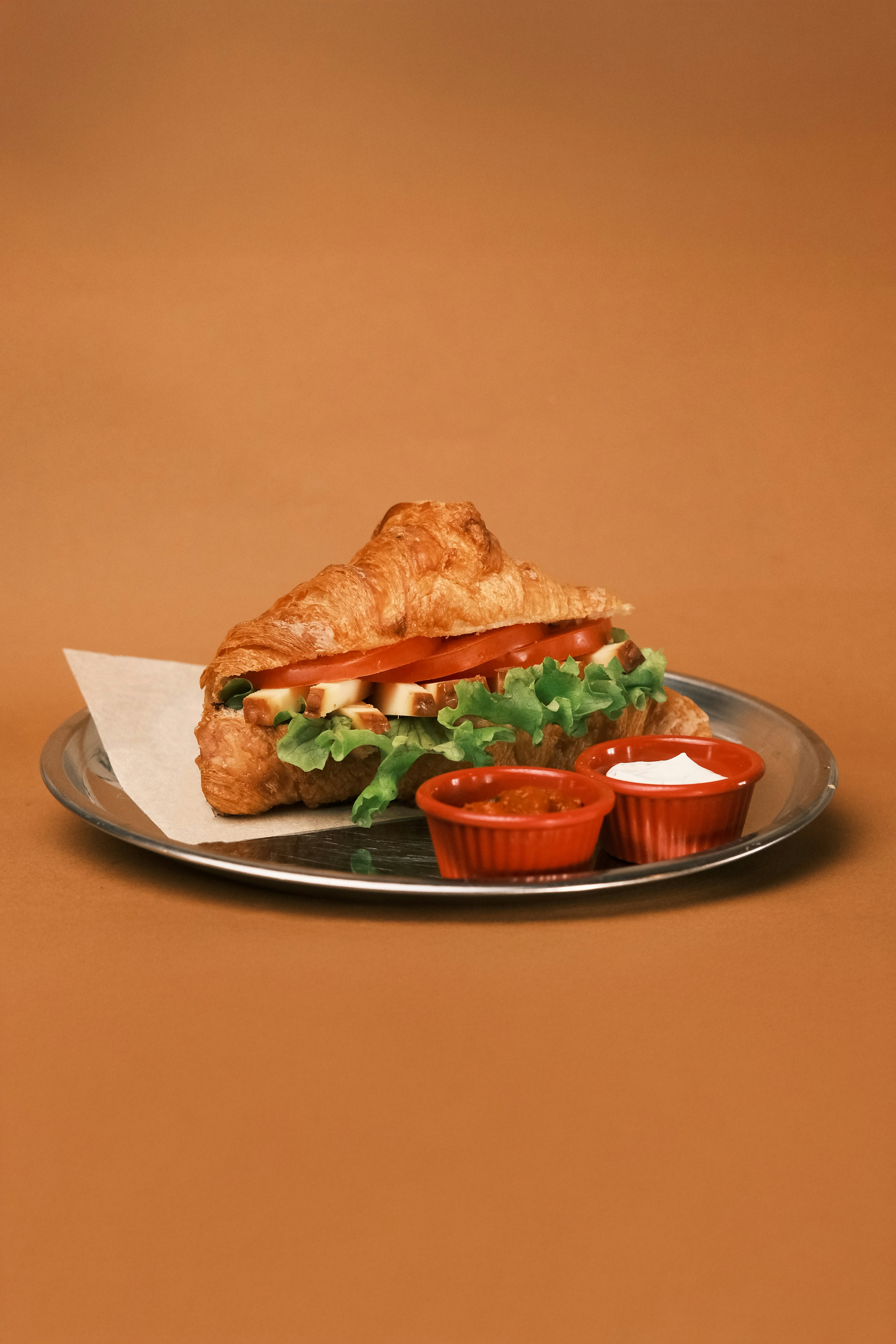 A sandwich with lettuce and tomato sauce on a plate