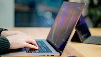A person using a laptop on a wooden table