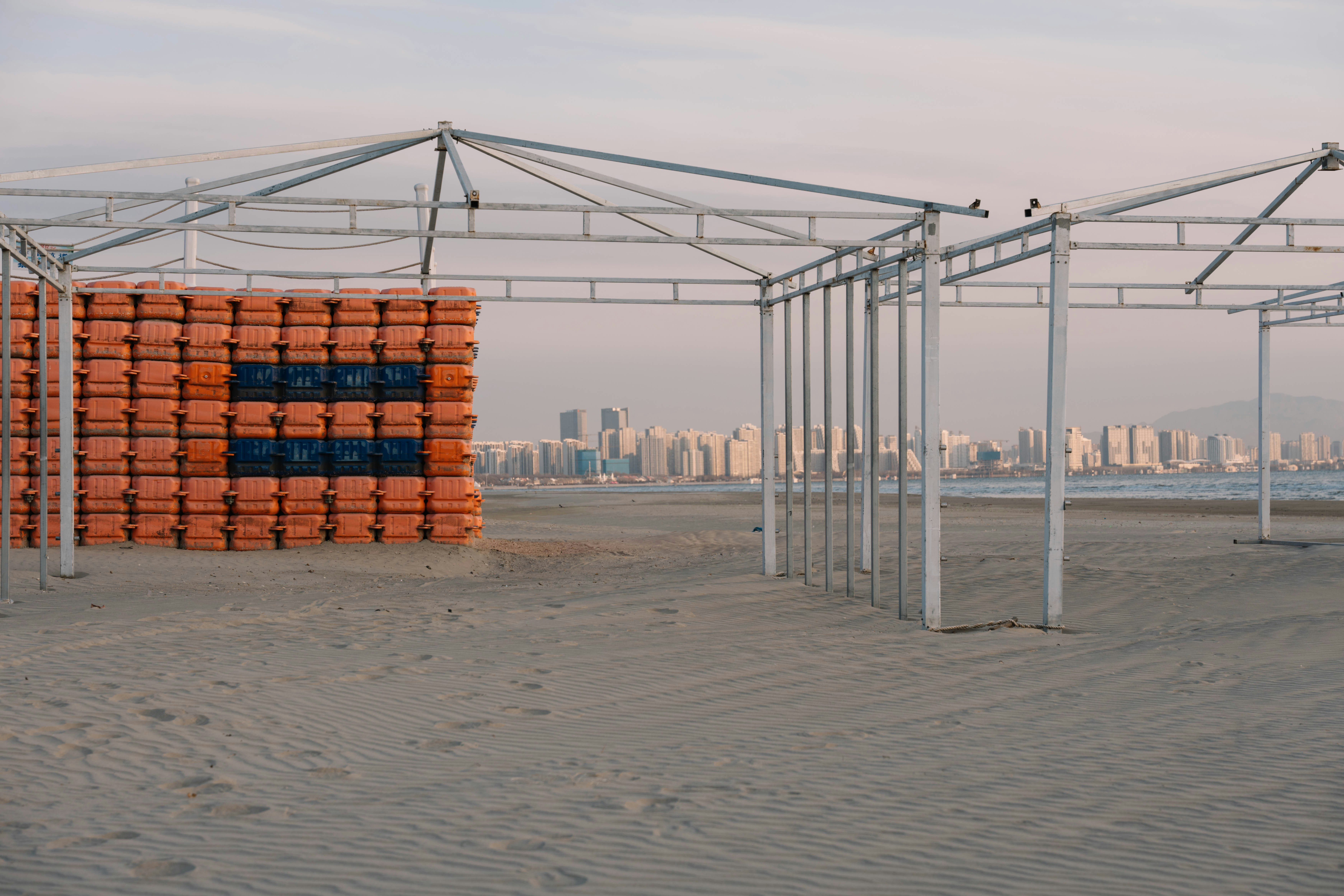 A group of orange boxes sitting on top of a sandy beach