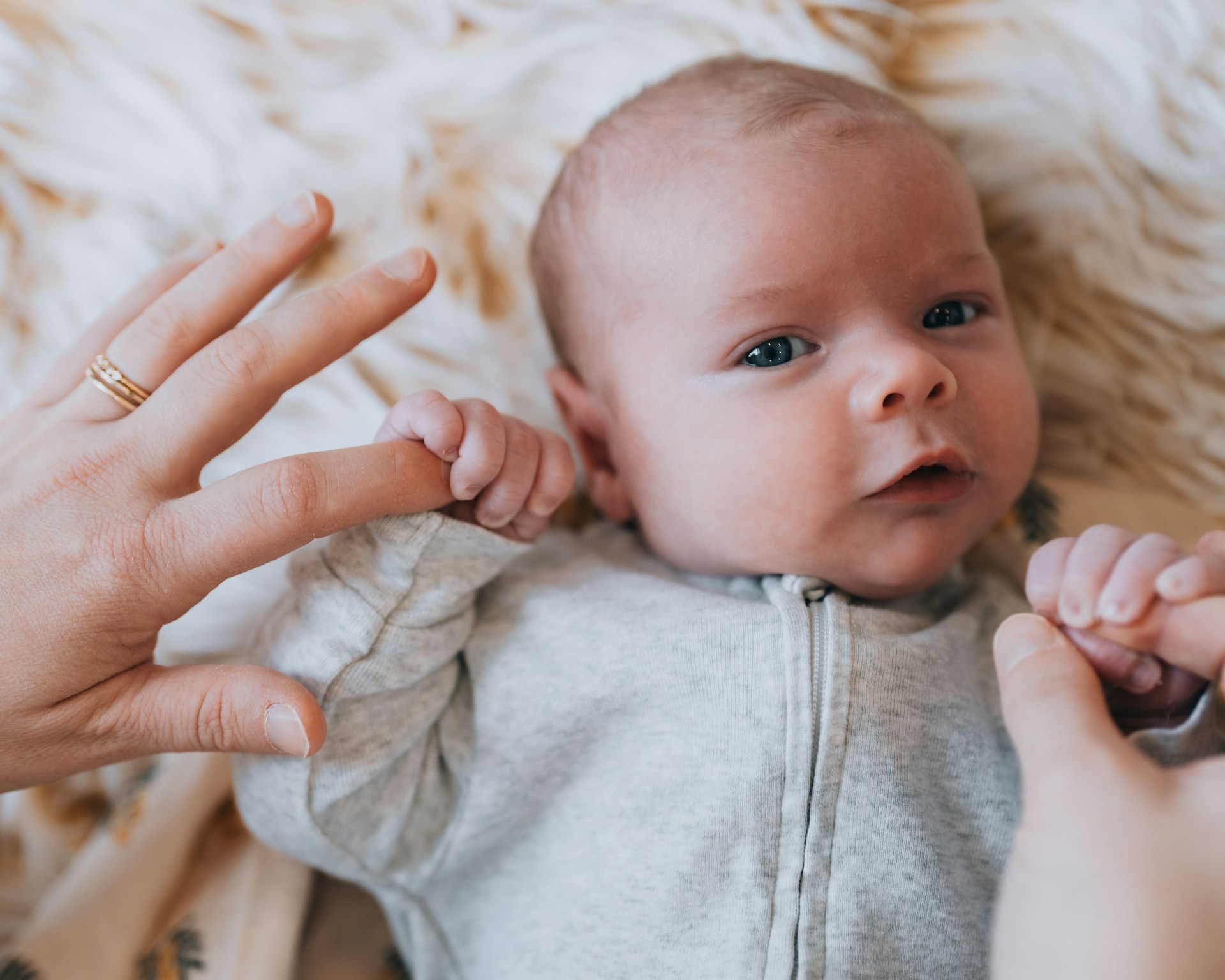 A baby being held up by a woman's hand