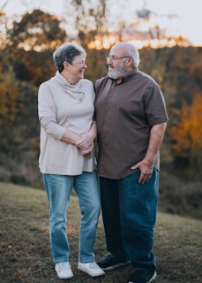 A man and woman standing next to each other in a field