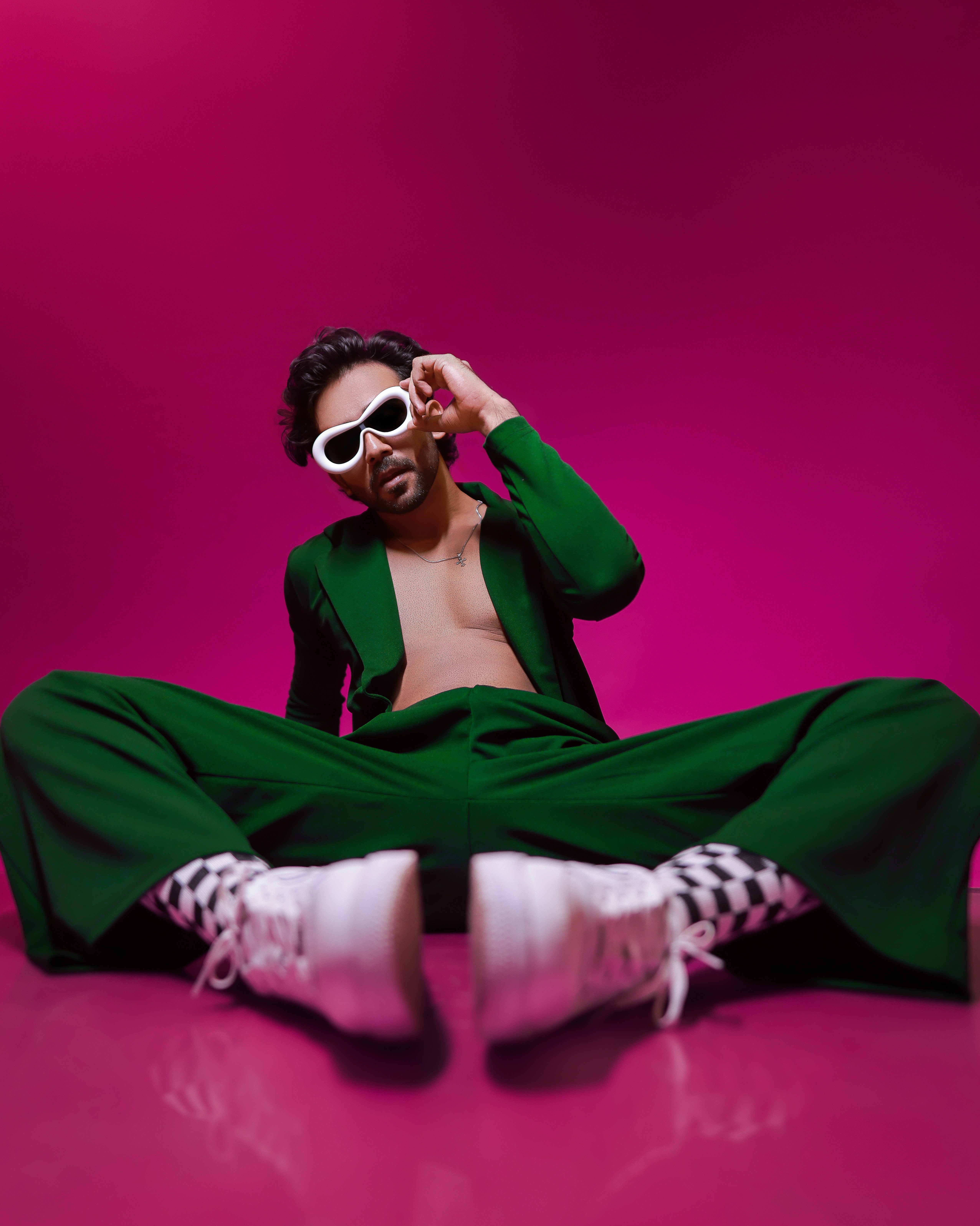A man sitting on the ground wearing sunglasses