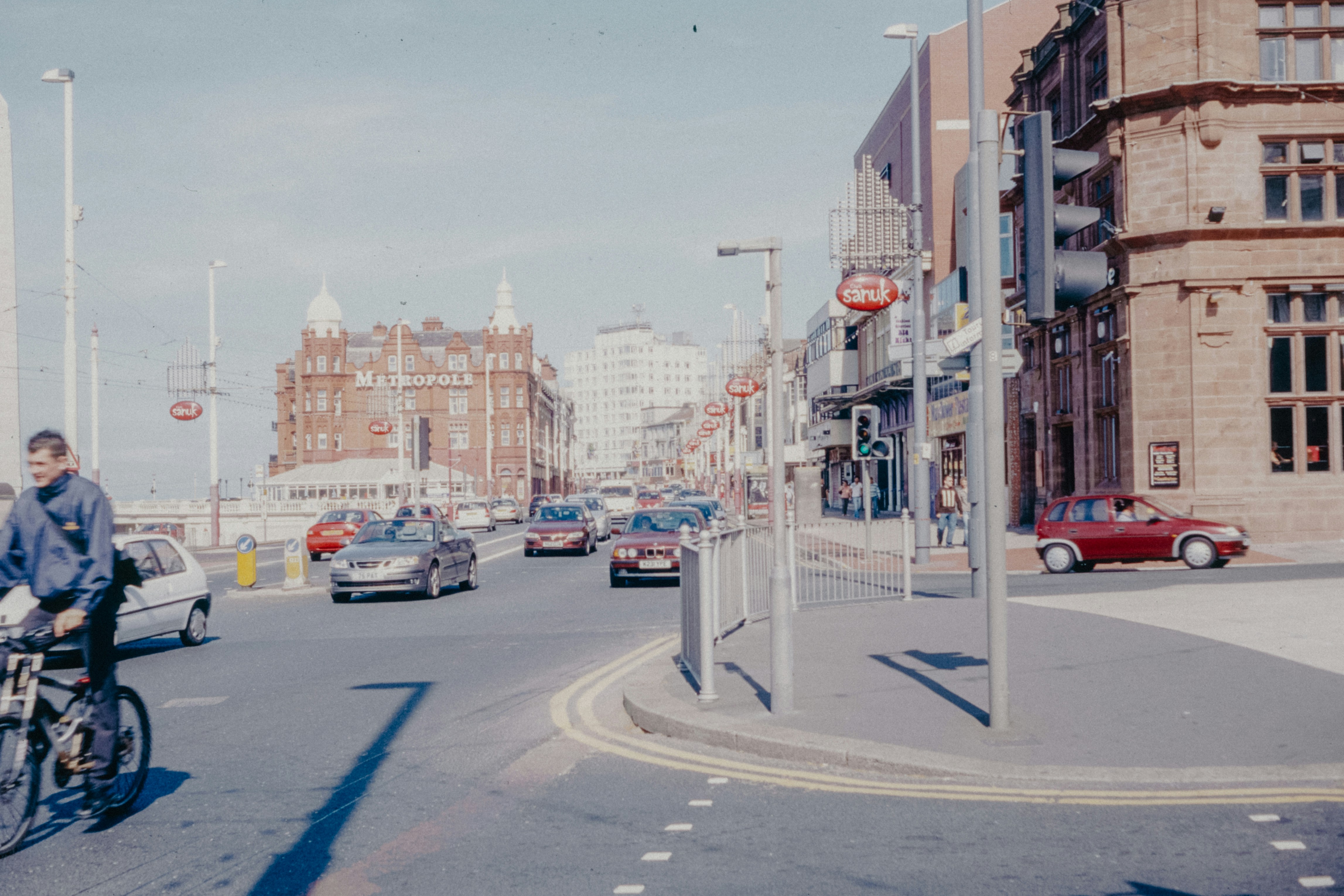 A man riding a bike down a street next to tall buildings