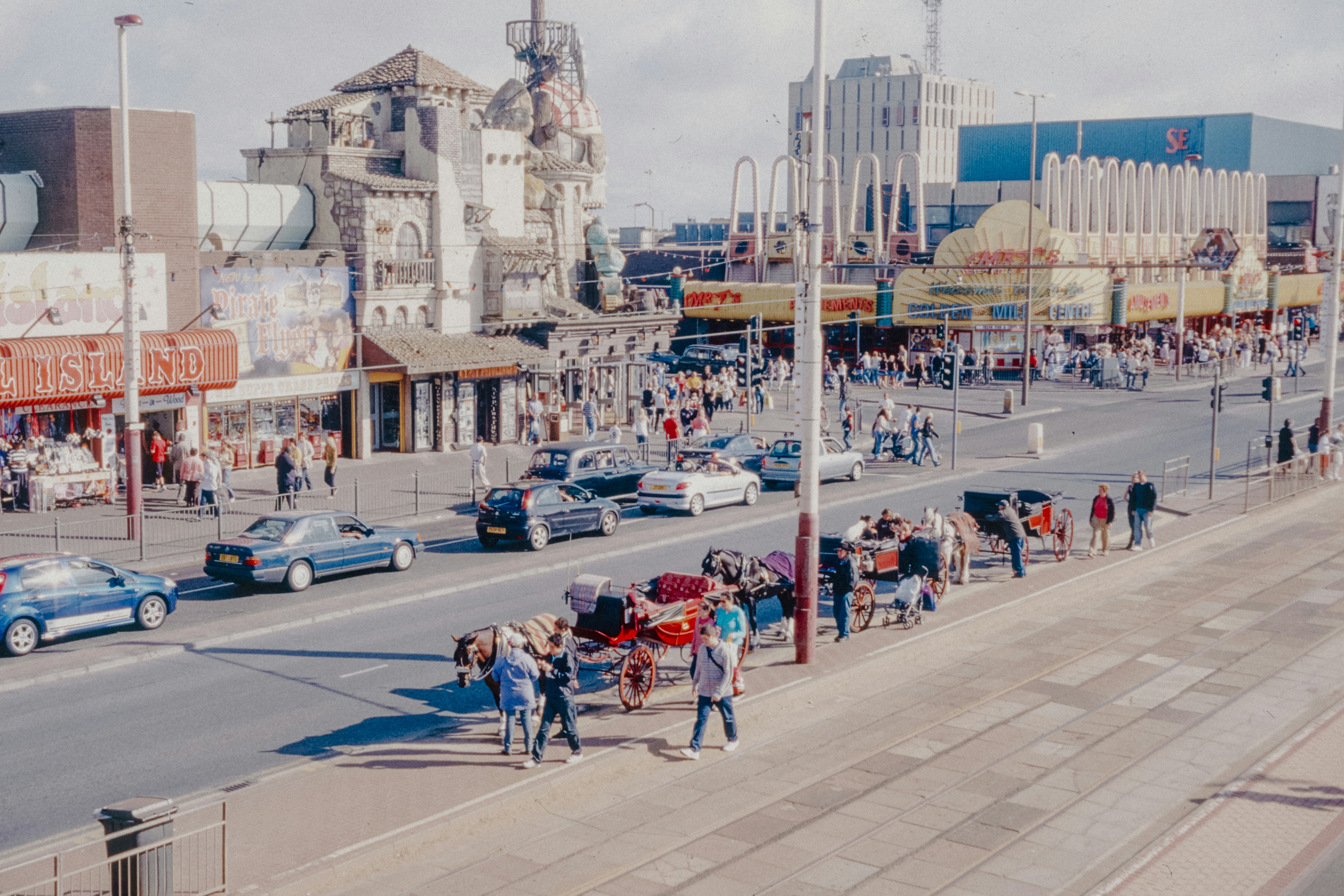 A crowd of people standing on the side of a road