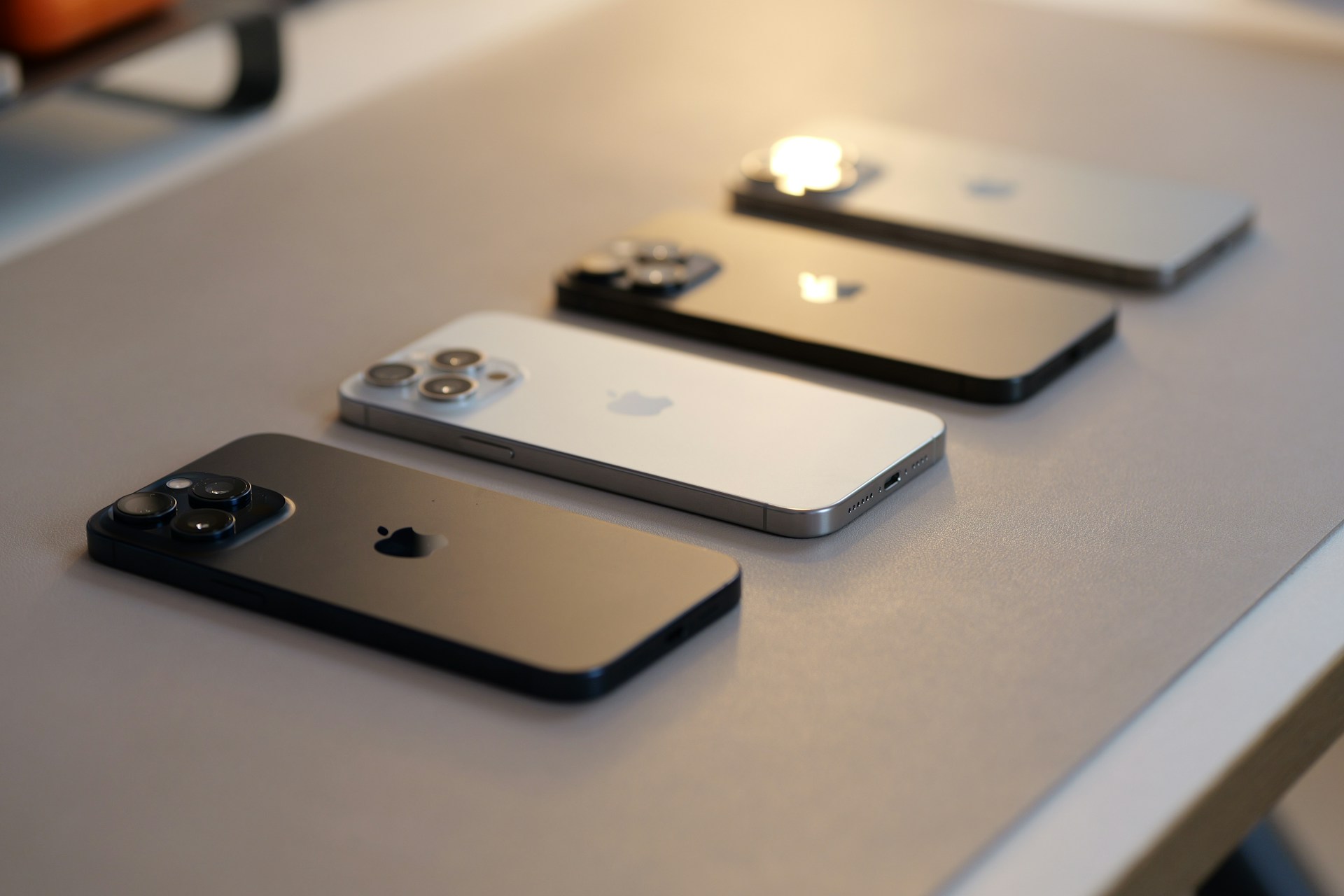 Three iphones sitting on a table next to each other