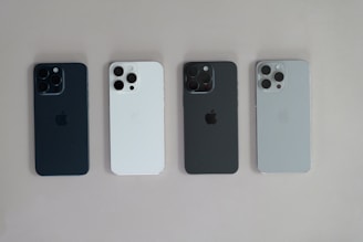 A group of four cell phones sitting next to each other