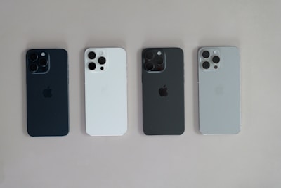 A group of four cell phones sitting next to each other