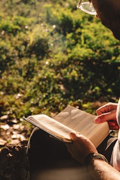 A man sitting on a bench reading a book