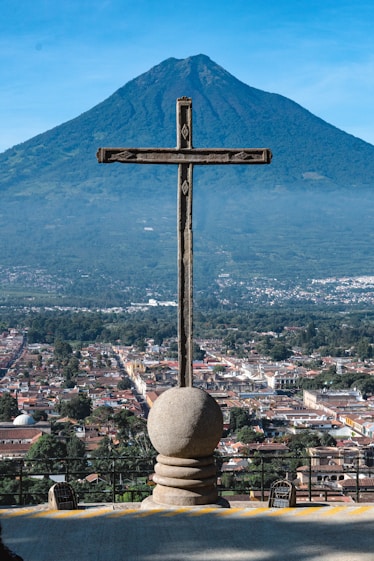 A cross on top of a building with a mountain in the background
