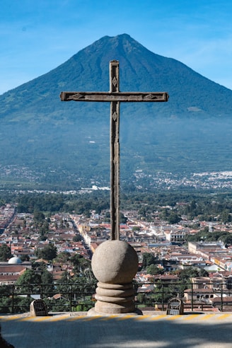 A cross on top of a building with a mountain in the background