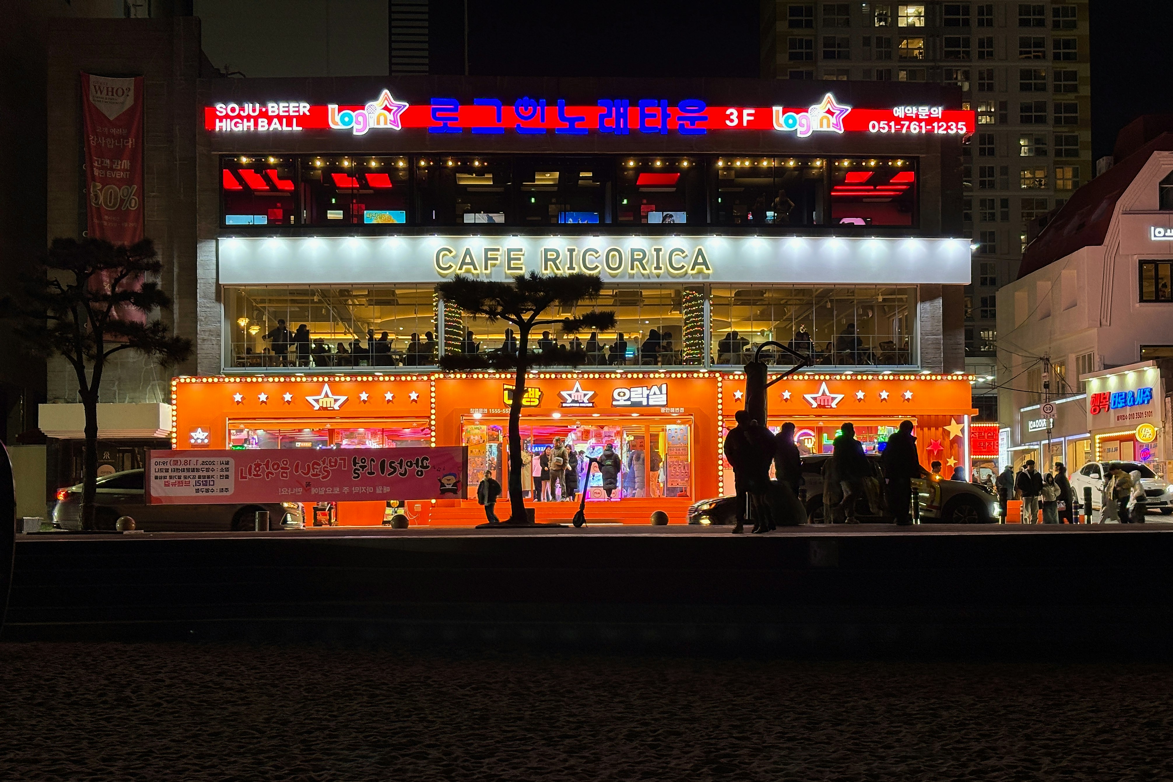 A group of people standing outside of a building at night