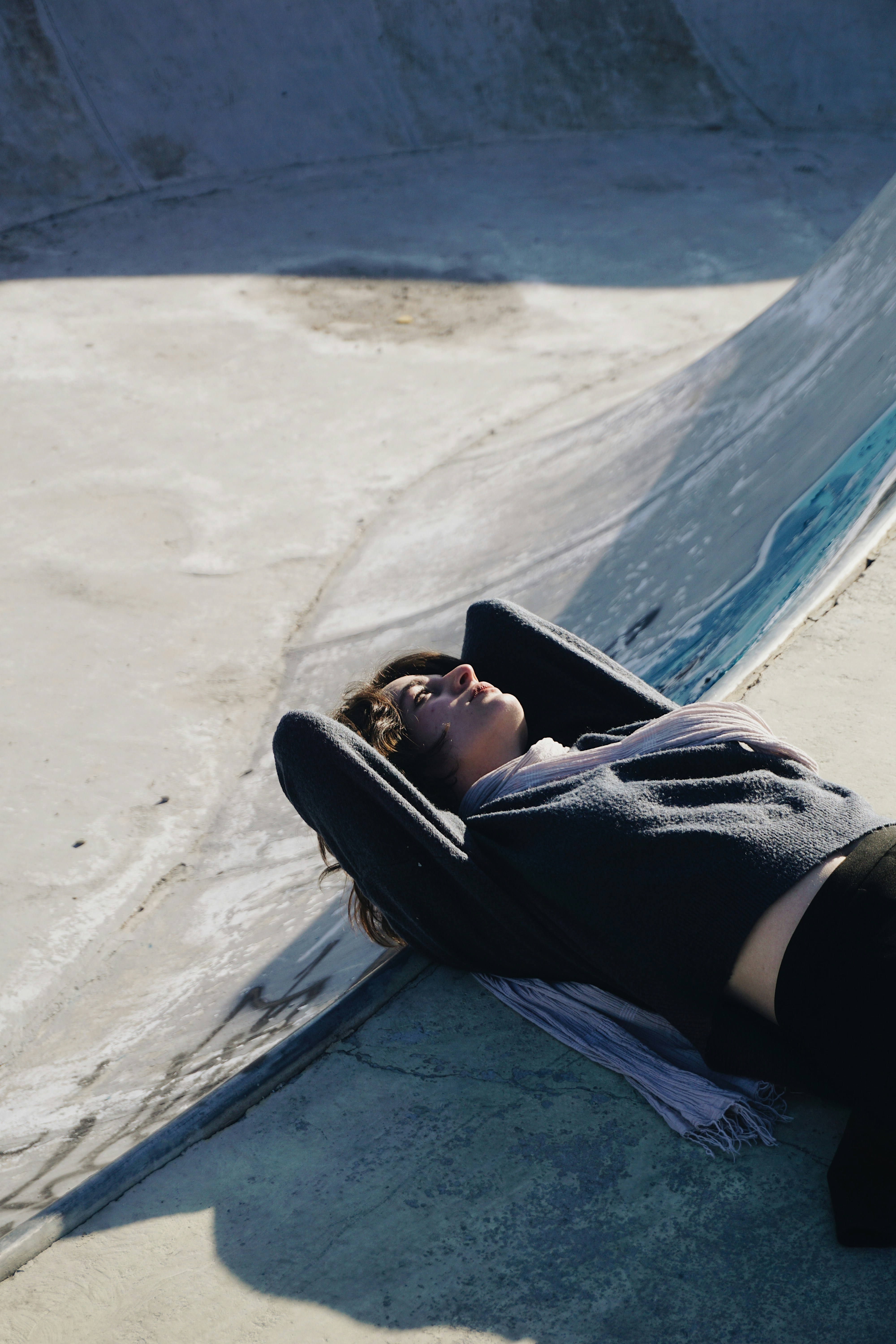 Una donna sdraiata a terra accanto a una rampa da skateboard