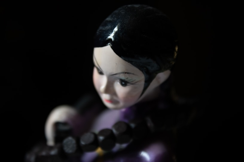 A close up of a figurine holding a remote control