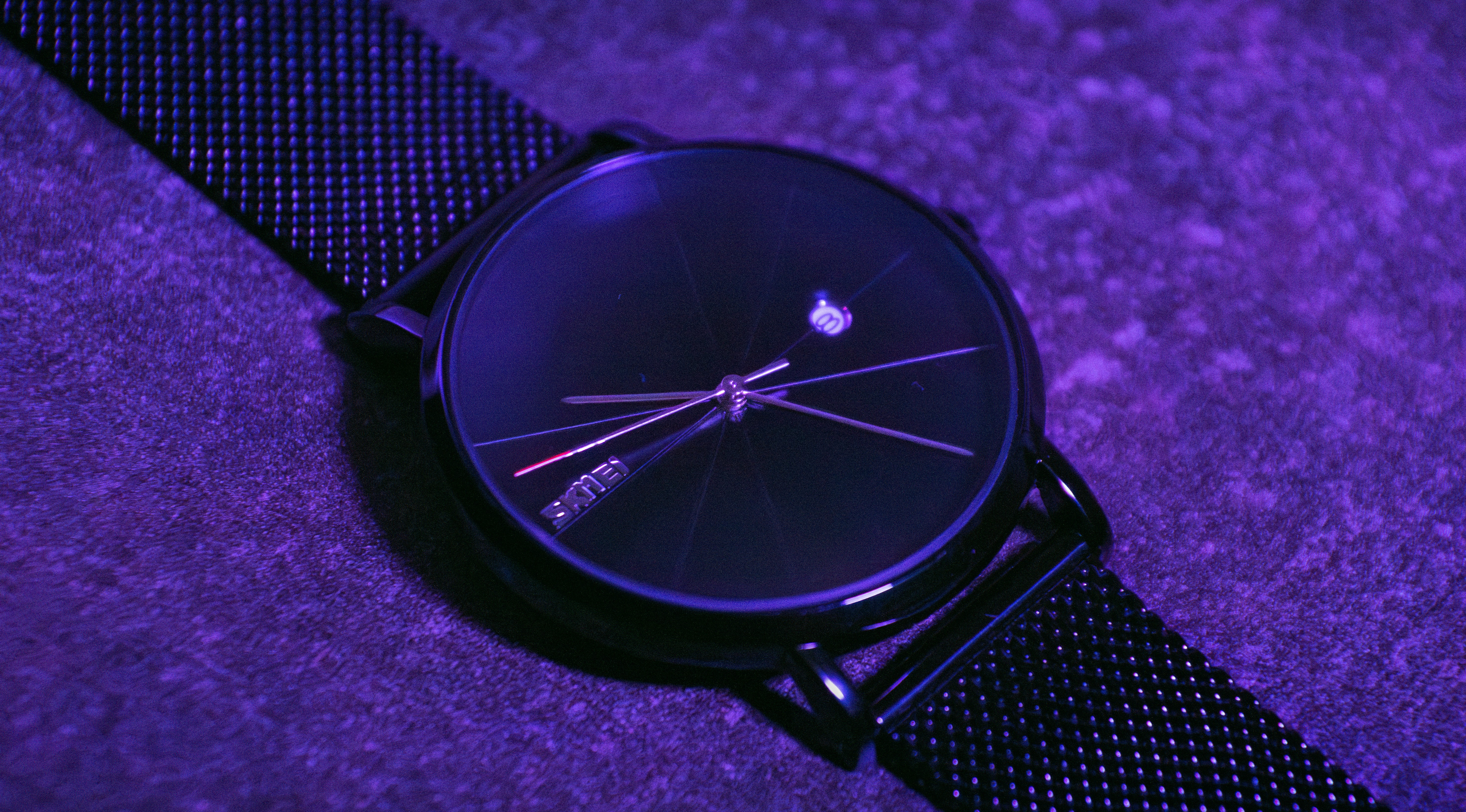 Une montre posée sur une surface violette