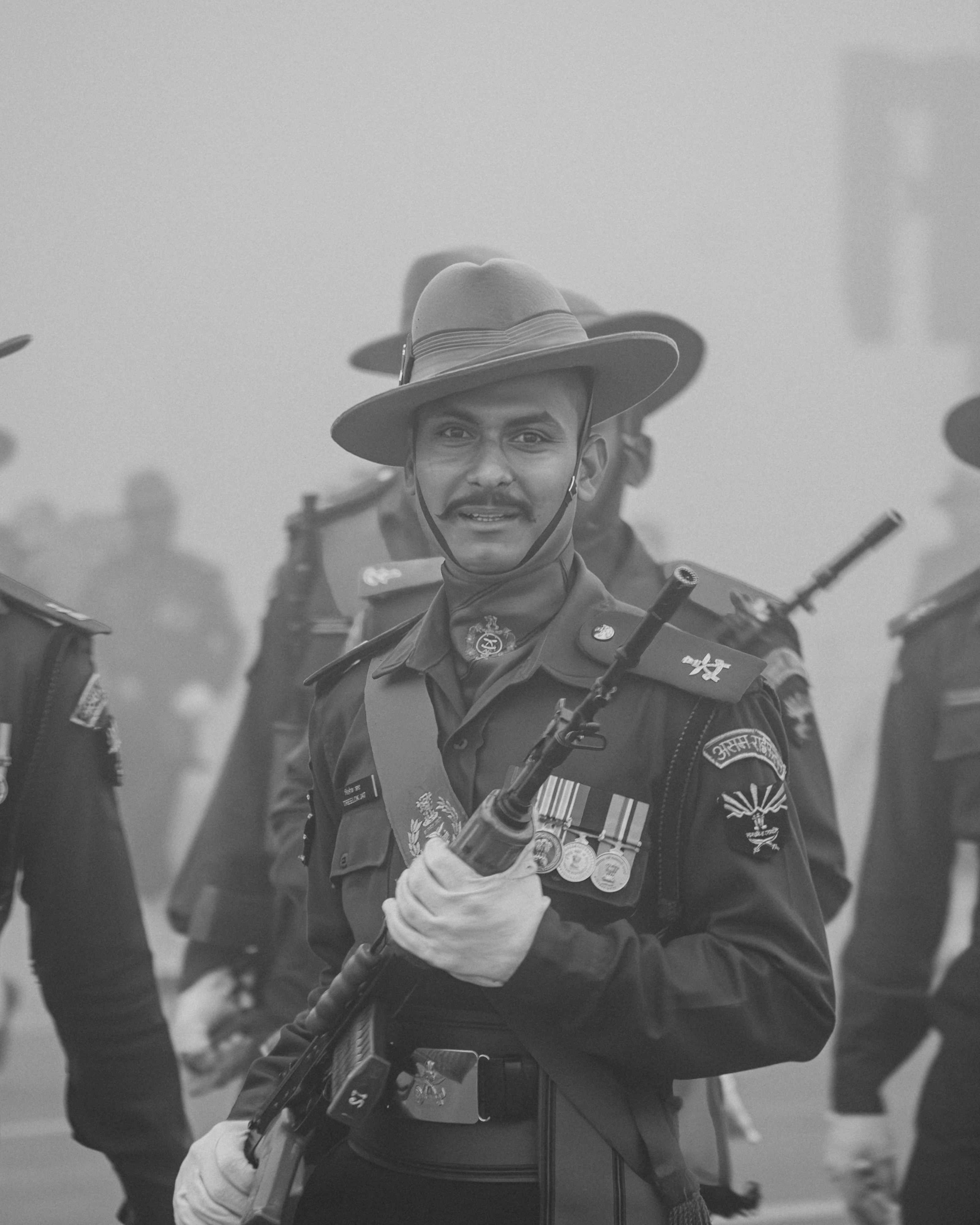 A group of men in uniform marching down a street photo – Free Gun Image ...